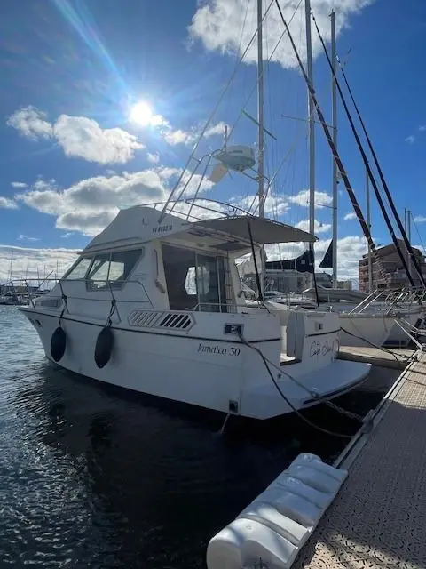 Gib Sea Jamaica 30 — Bateau à moteur blanc amarré au ponton, sous un ciel dégagé.
