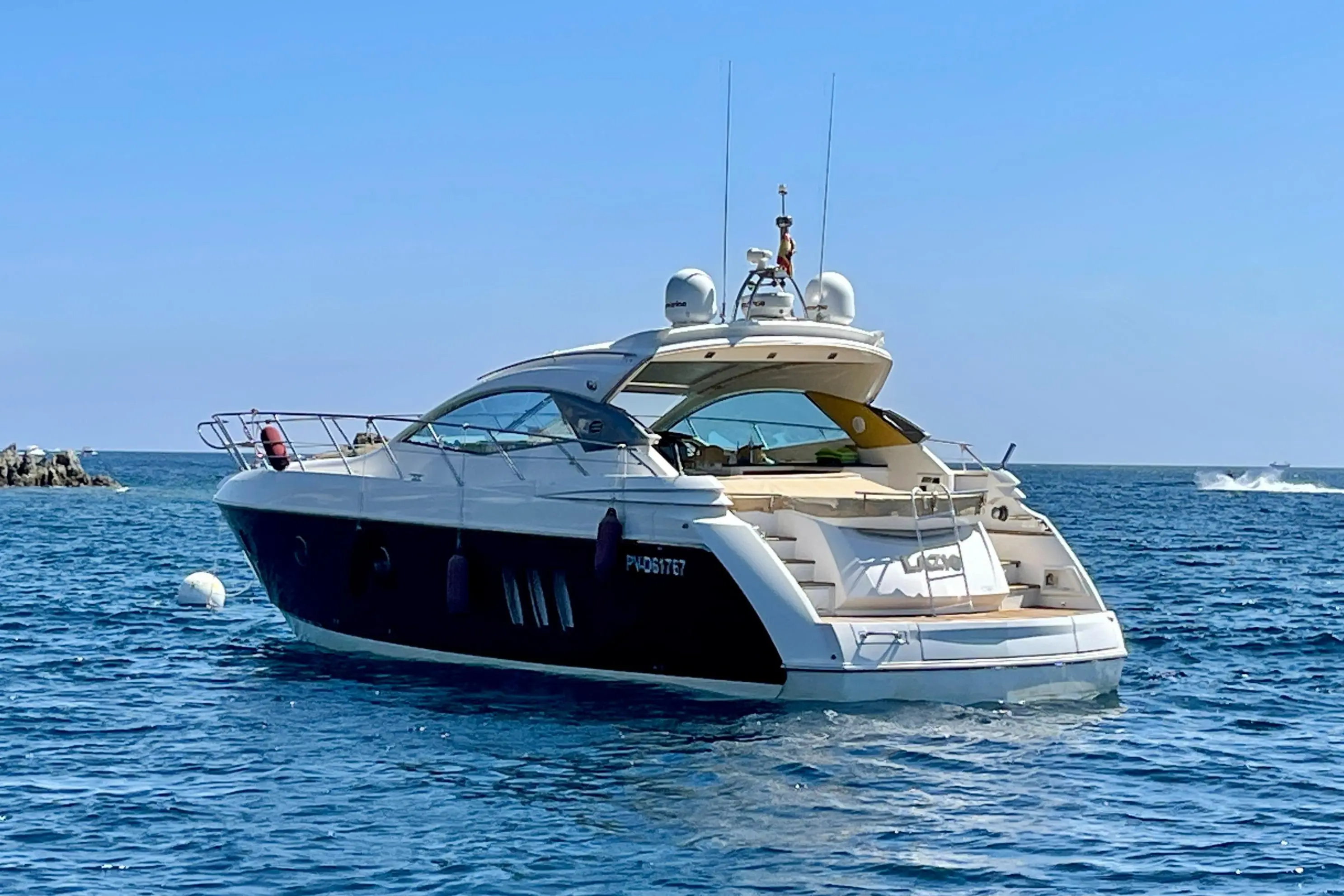 Sessa Marine C46 — Bateau à moteur vu de trois quarts arrière au mouillage, en mer.