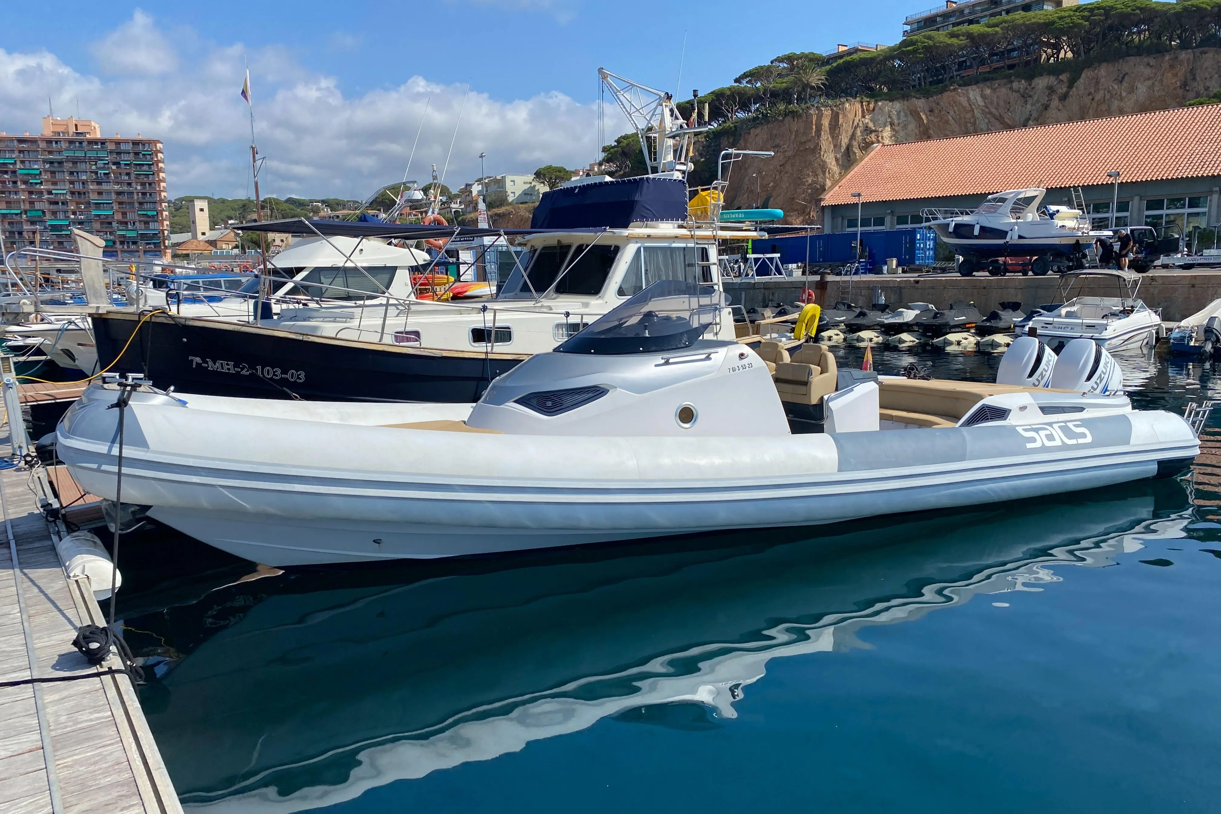 Sacs Strider 11 — Bateau pneumatique gris et blanc amarré dans un port, vu de profil.