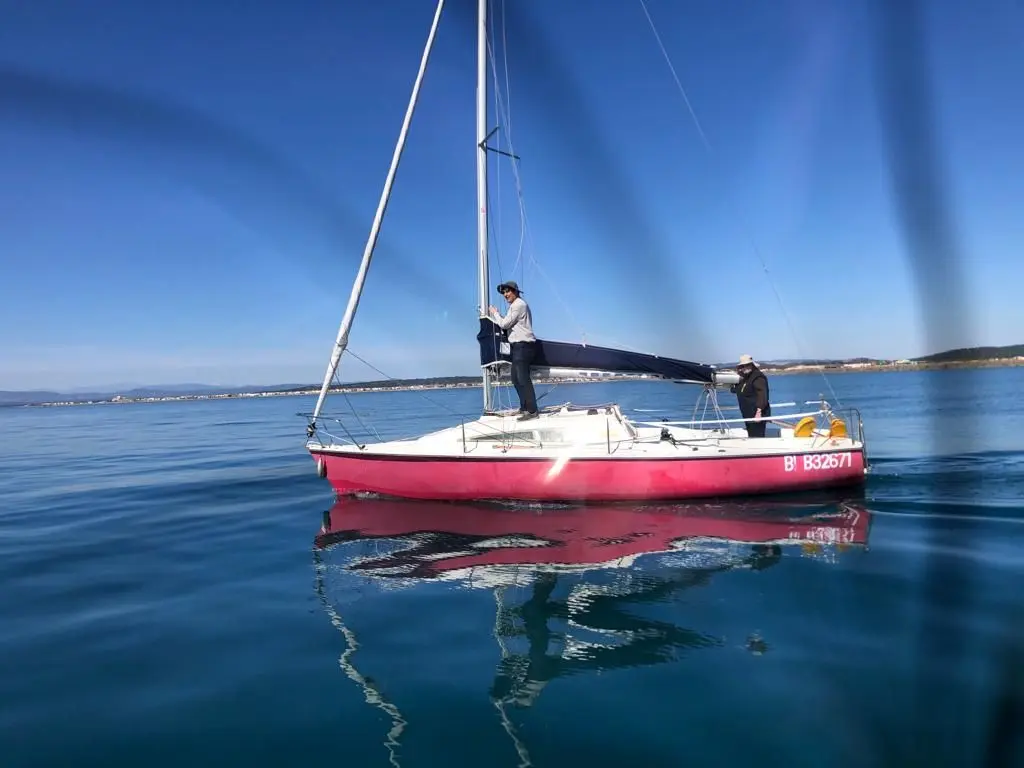 Archambault Surprise — Voilier vu de profil sur une mer calme, avec deux personnes à bord.