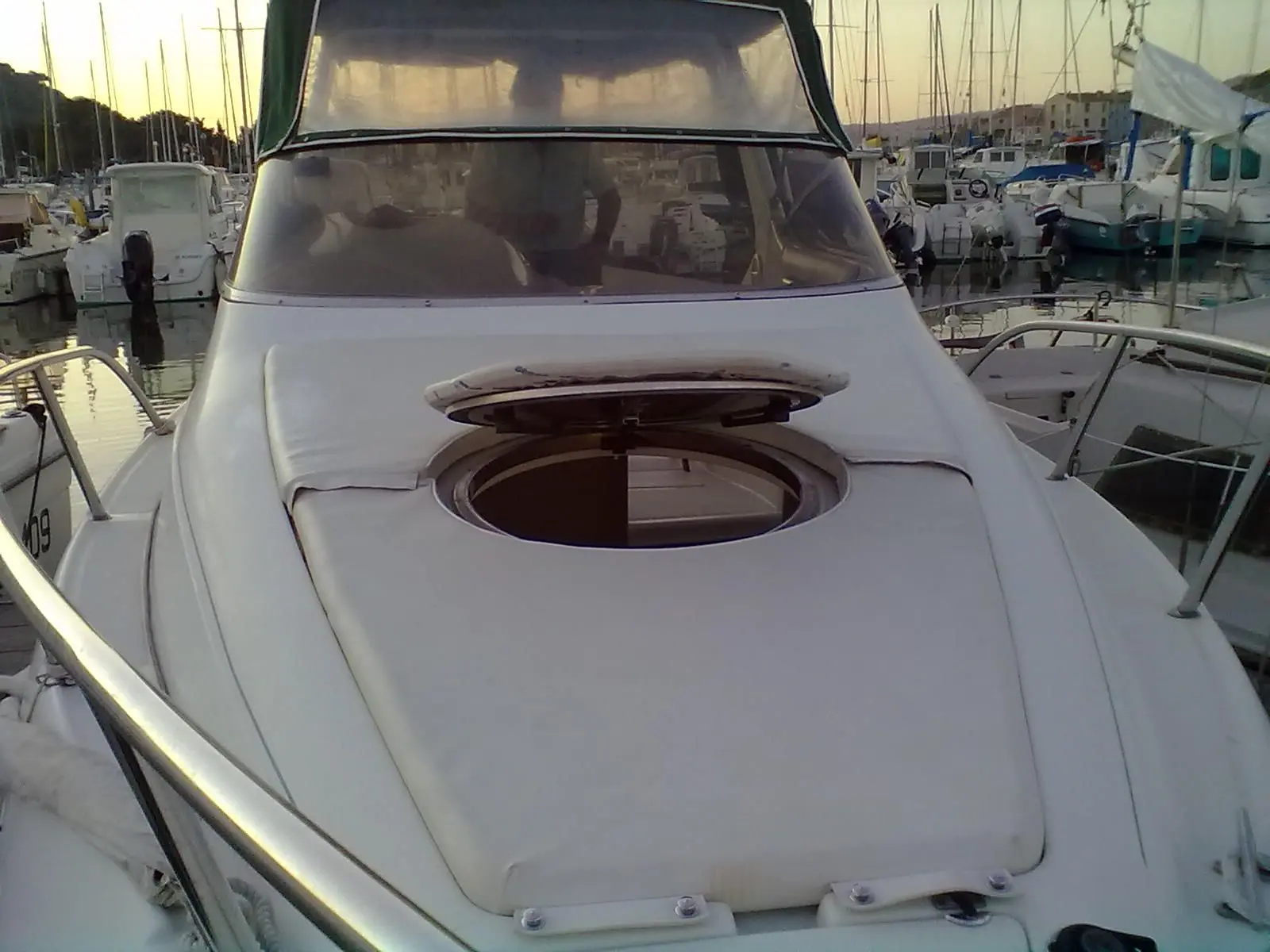 Sessa Marine Oyster 22 — Vue avant d’un bateau à moteur amarré, avec hublot de pont et pare-brise visibles.