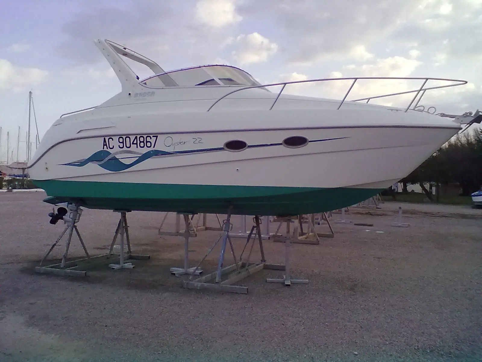 Sessa Marine Oyster 22 — Bateau à moteur blanc et turquoise photographié à terre, vu de profil.
