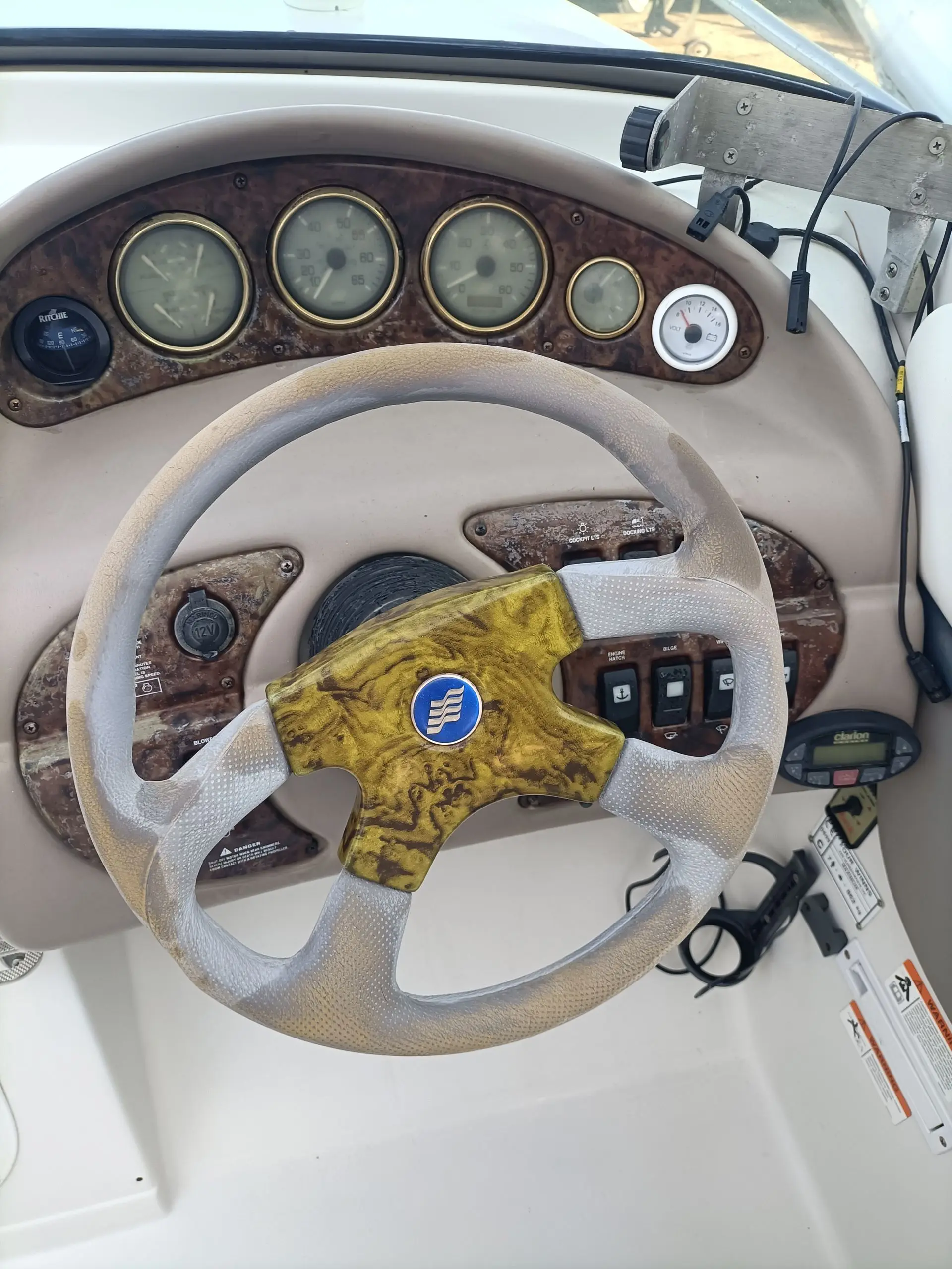 Four Winns Sundowner 225 — Vue rapprochée du poste de pilotage avec volant, instruments et commandes.