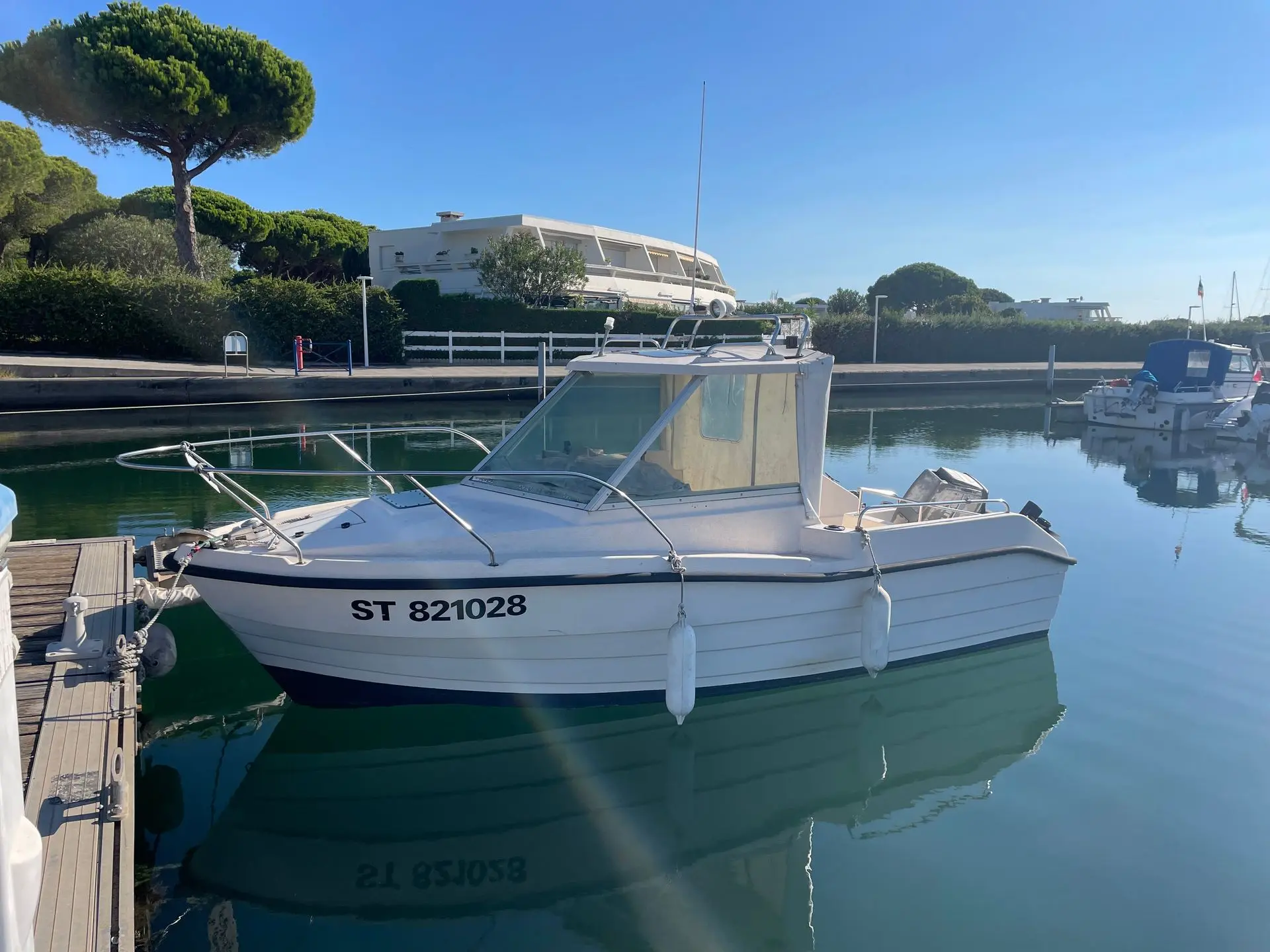 Clear Liner 530 Timonier — Bateau à moteur blanc amarré dans un port, vu de trois quarts.