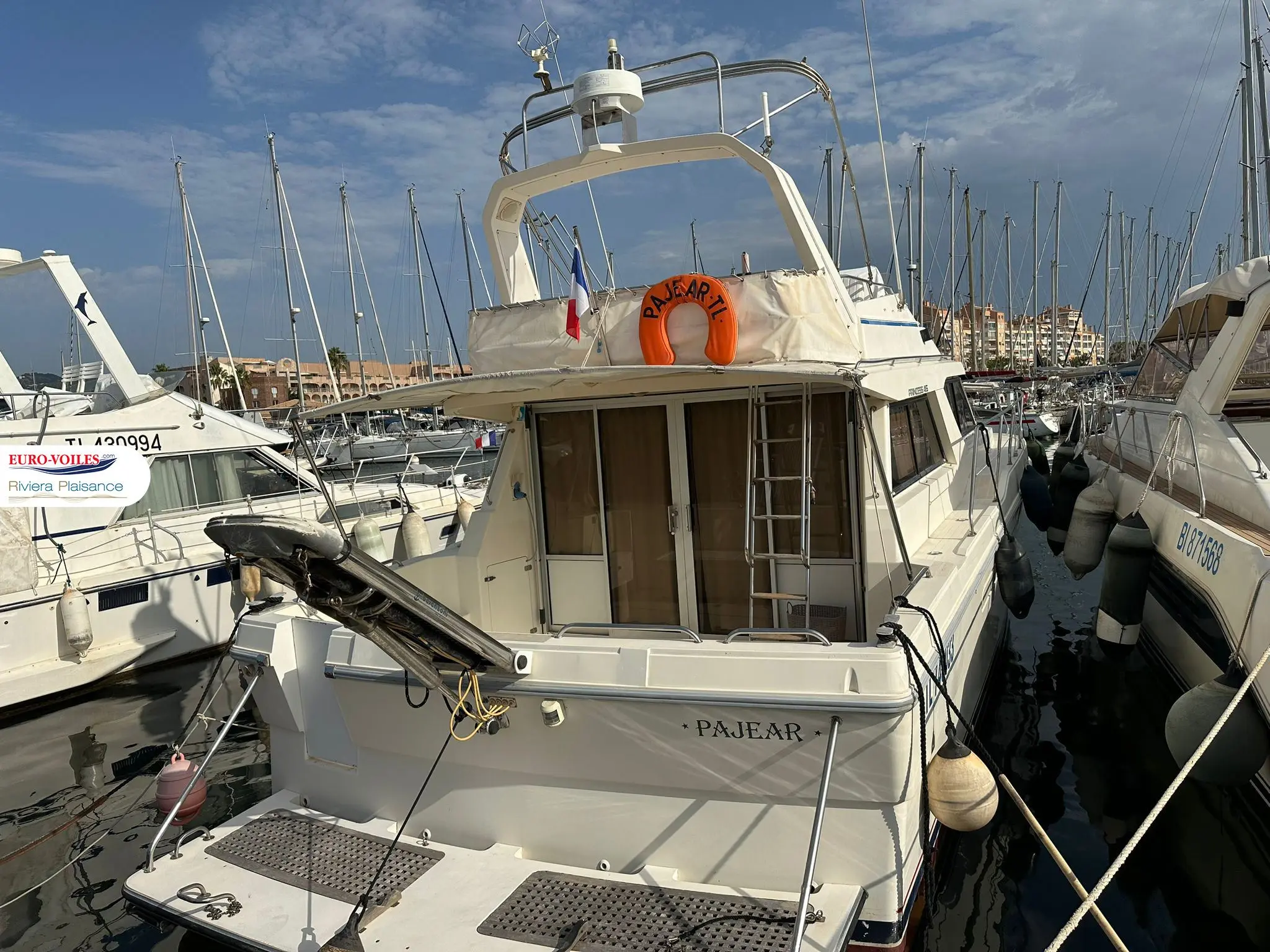 Princess 415 — Vue arrière trois-quarts d’un bateau à moteur amarré dans un port.