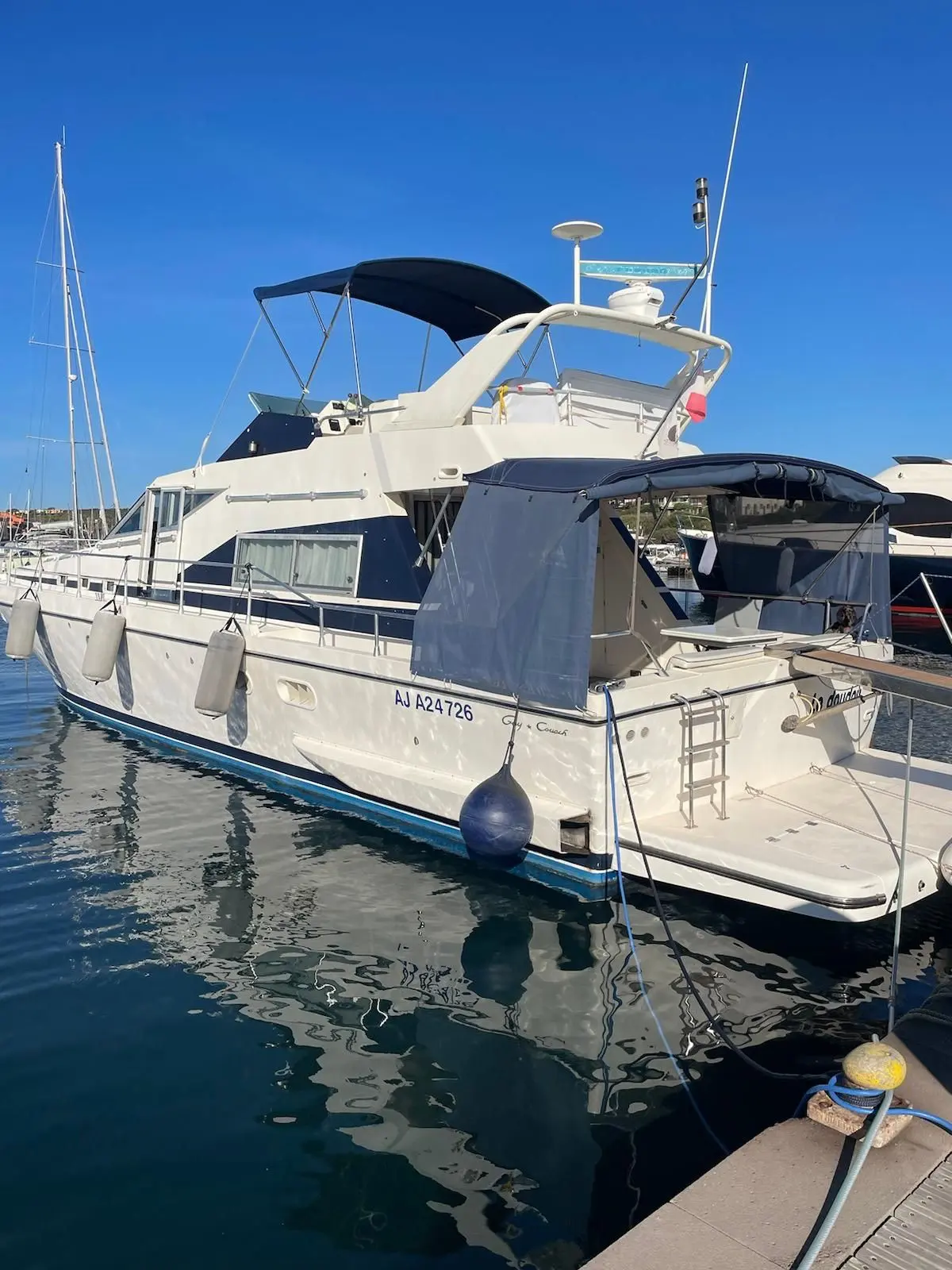 Guy Couach 1501 CL — Bateau à moteur amarré dans un port, vu de trois quarts arrière.