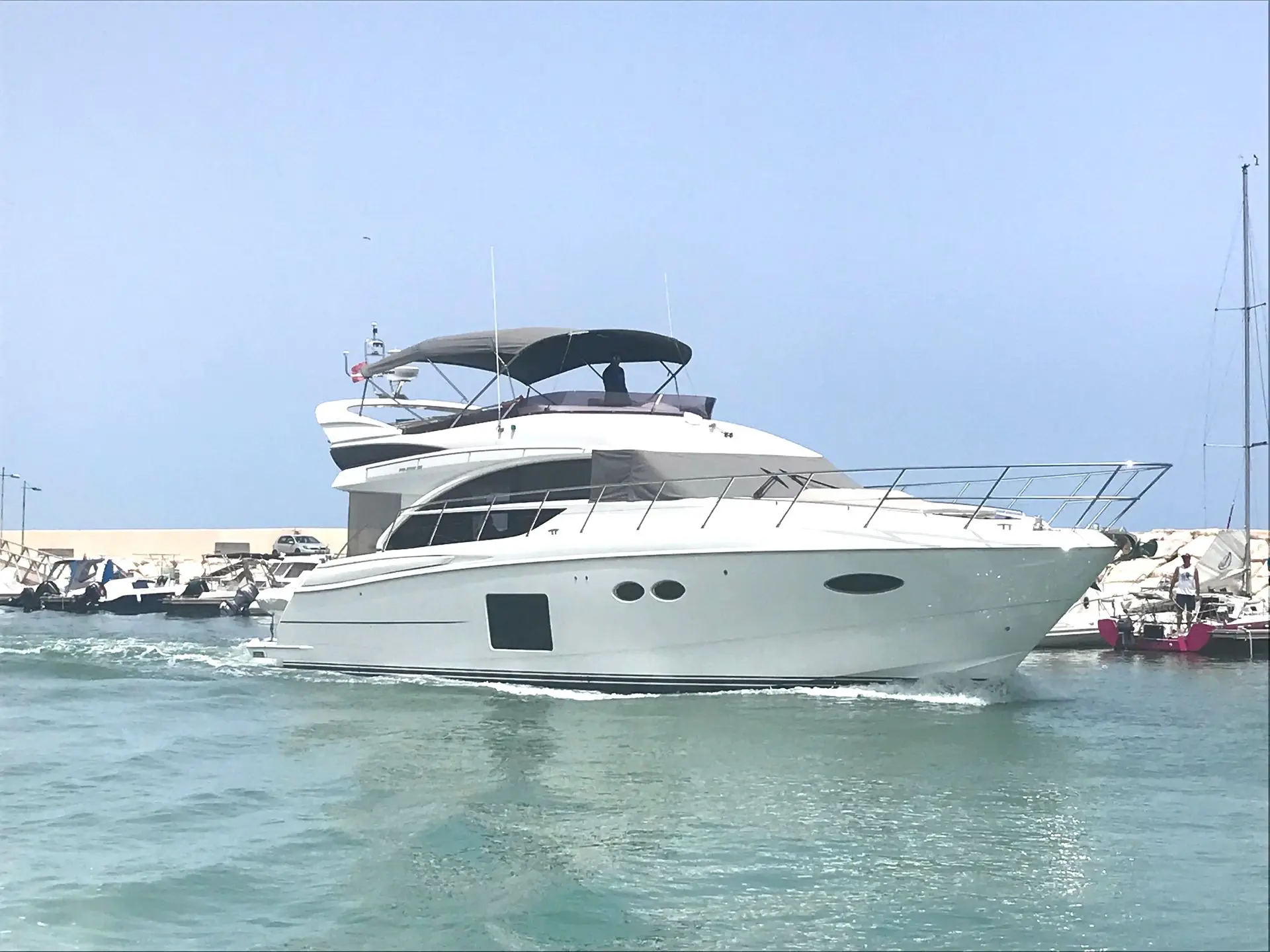 Princess 56 — Yacht à moteur blanc vu de trois quarts dans un port de plaisance.