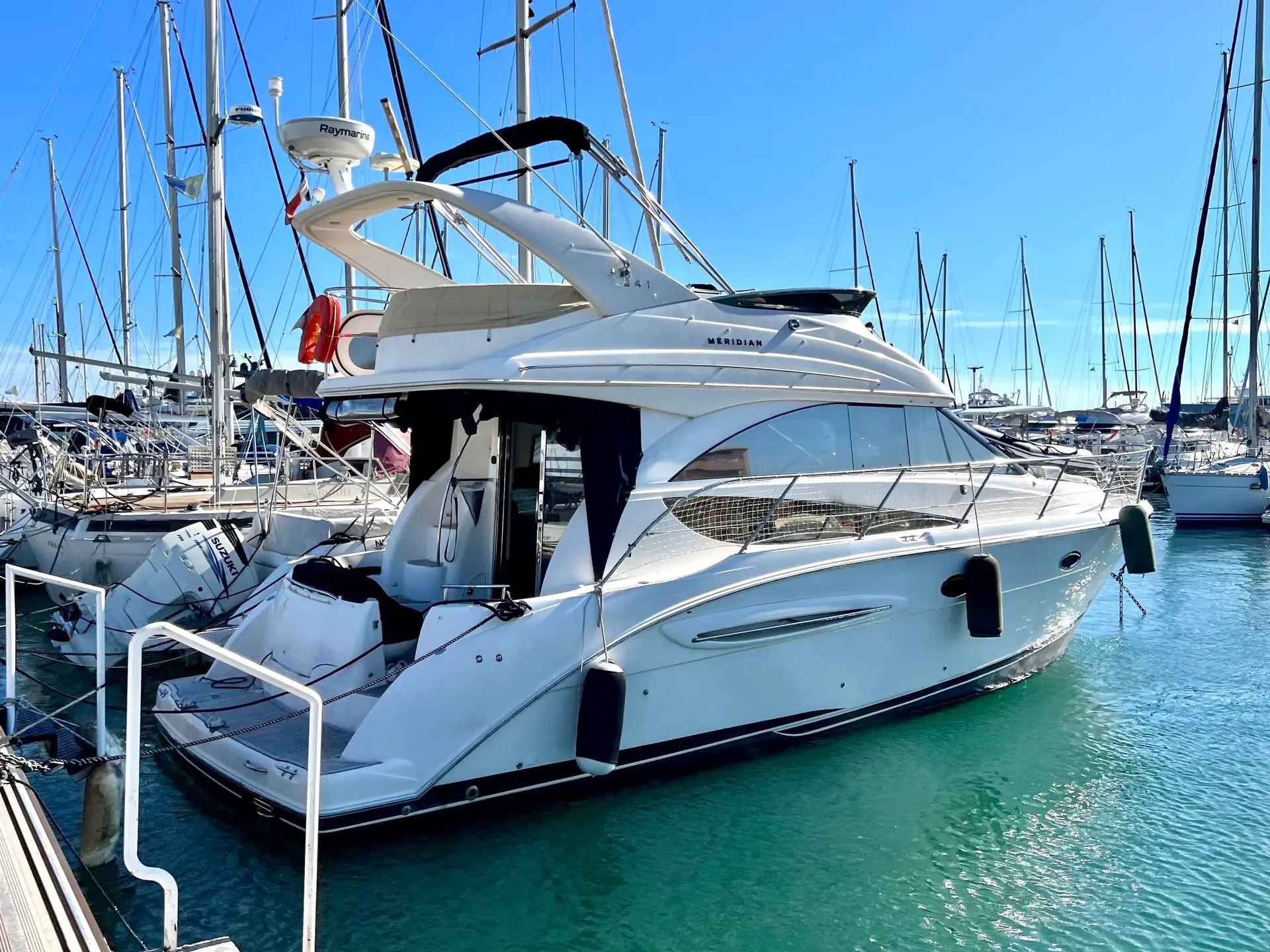 Meridian Yacht 341 — Bateau à moteur blanc vu de trois quarts arrière dans une marina.