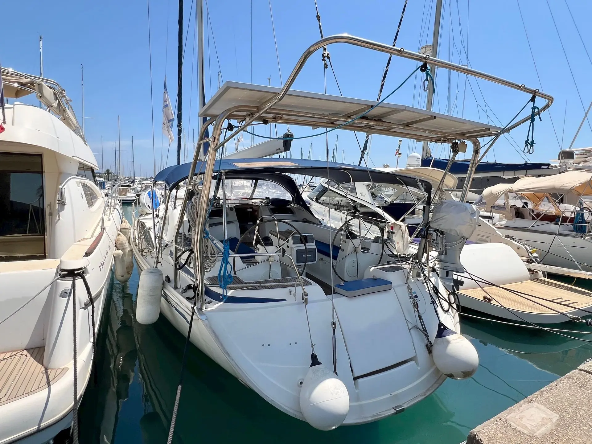 Bavaria 50 Vision — Voilier blanc vu de l’arrière, amarré dans un port de plaisance ensoleillé.