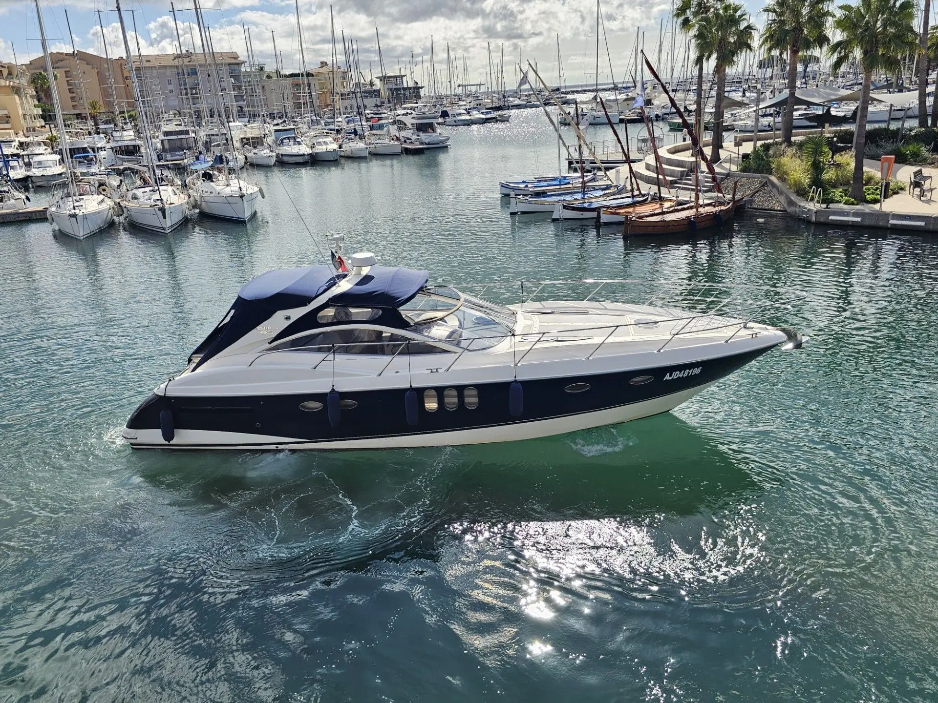 Absolute 45 — Bateau à moteur blanc et bleu photographié de profil dans un port de plaisance.