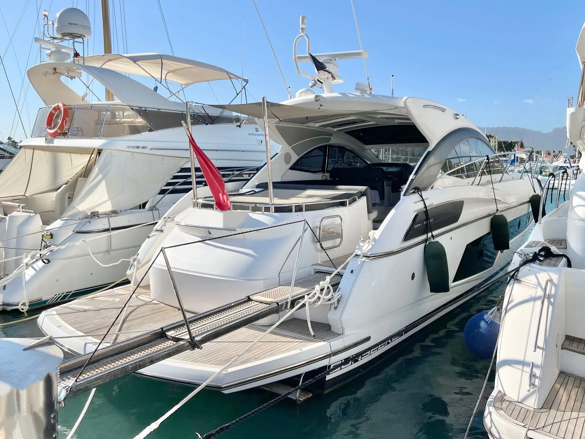 Sunseeker San Remo 485 — Bateau à moteur blanc amarré dans une marina, vu de trois quarts avant.