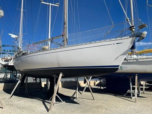 Dufour 38 — Voilier blanc à l’arrêt sur bers dans un chantier nautique.
