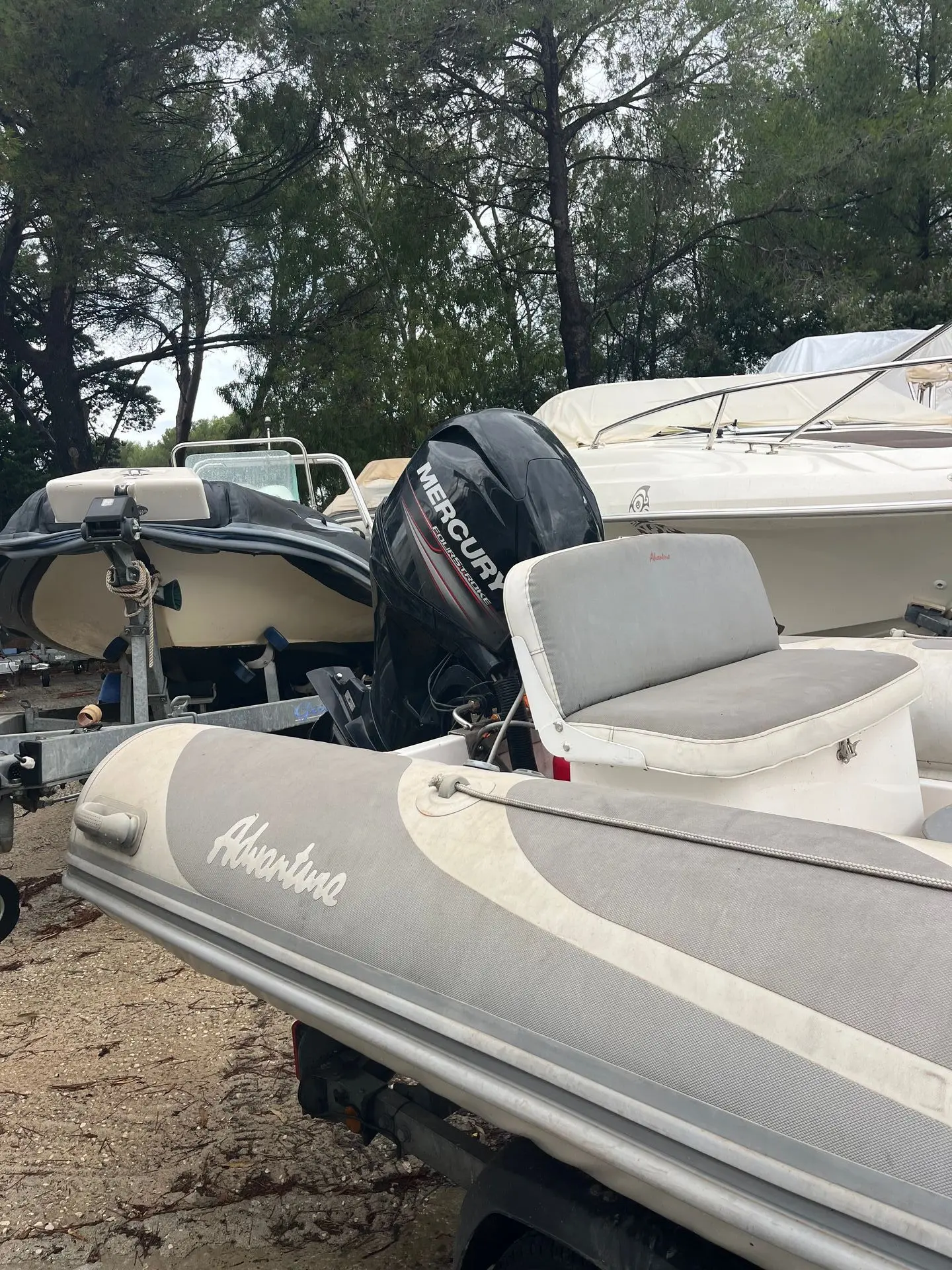 Adventure V-550 — Arrière partiel d’un bateau pneumatique sur remorque, avec moteur hors-bord.
