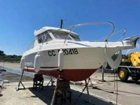B2 Marine Cap Ferret 720 — Bateau à moteur blanc et rouge posé sur bers à terre.