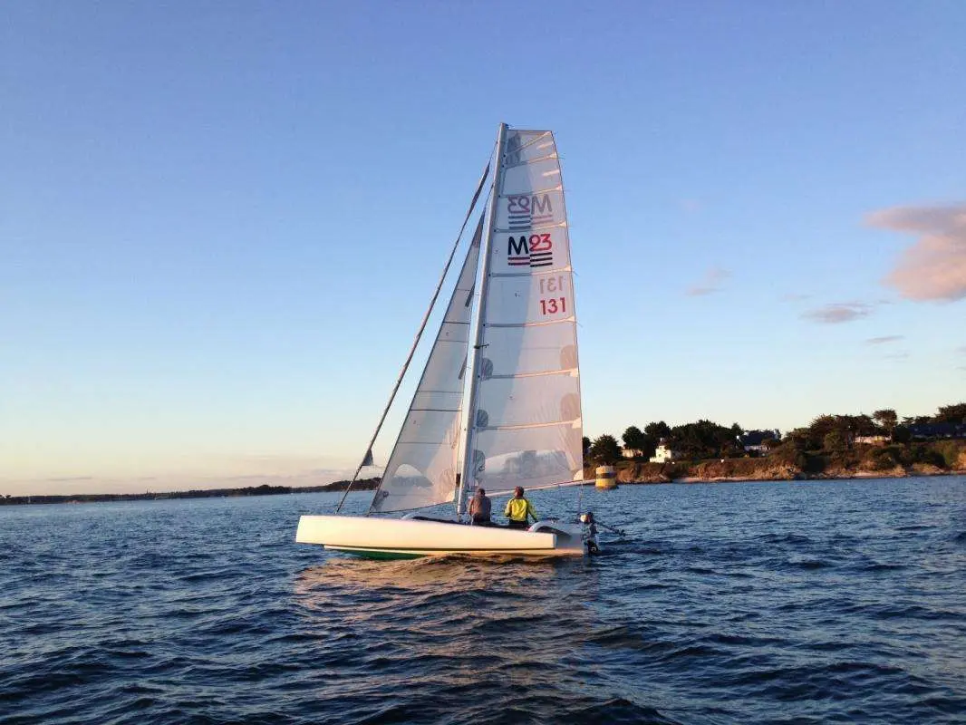 Torpen Multi 23 Trimaran — Voilier blanc naviguant au large, avec deux personnes à bord.