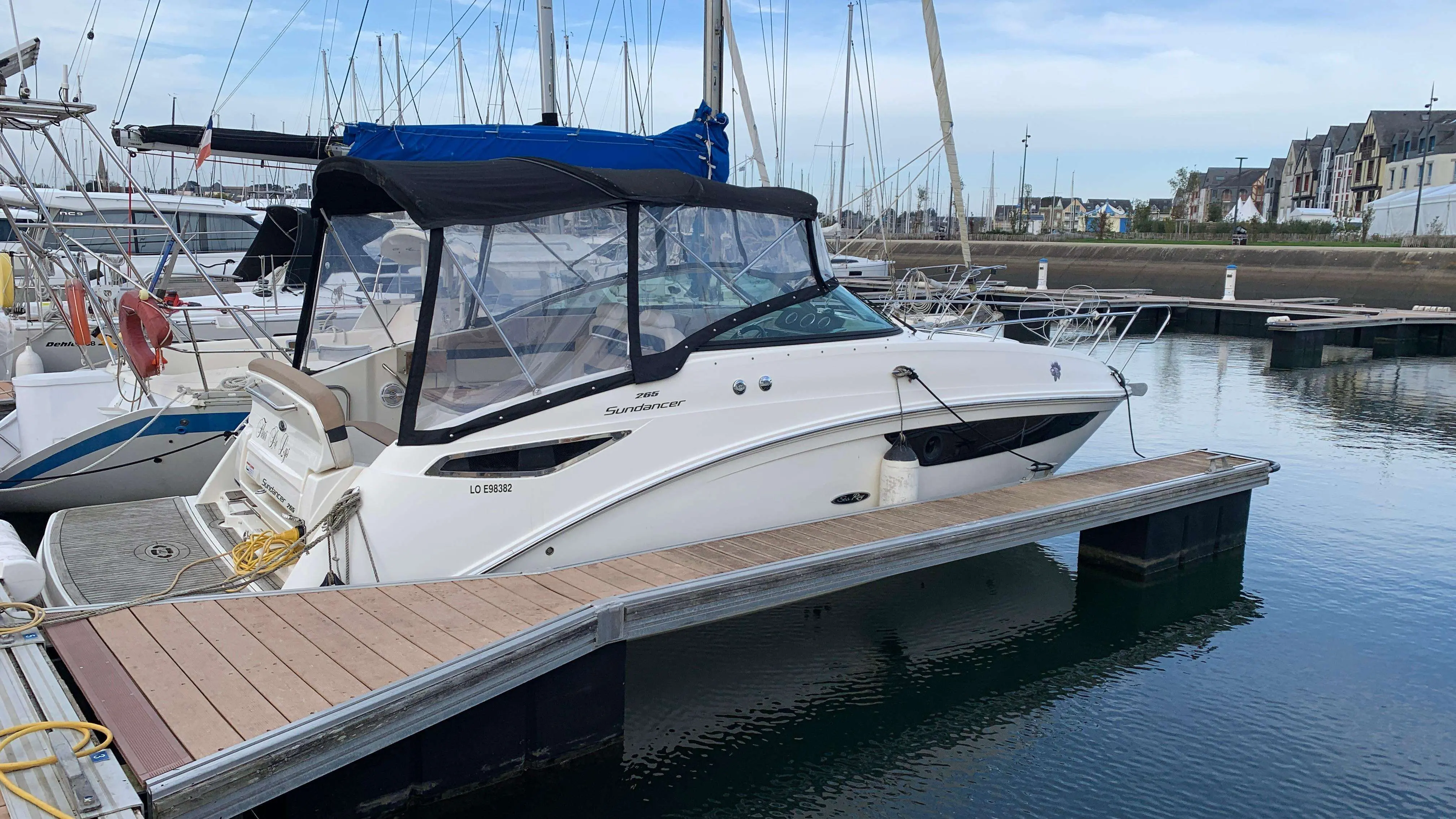 Sea Ray Sundancer 265 — Bateau à moteur blanc amarré dans un port, vu de trois quarts.