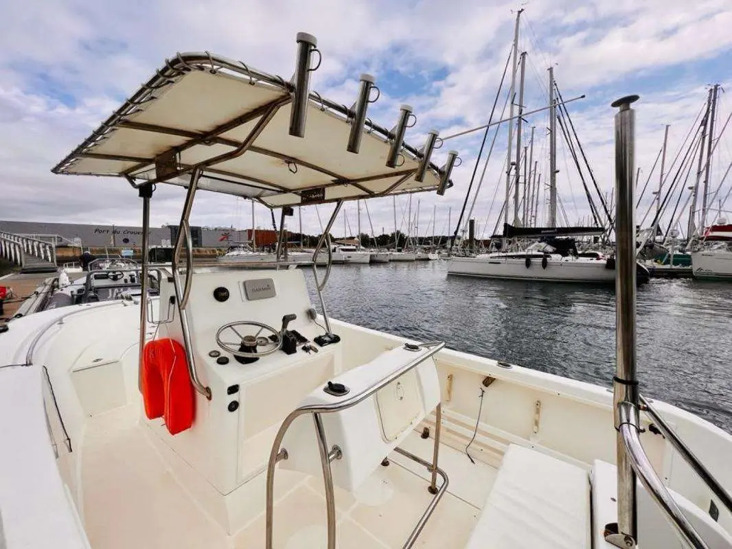 Uniquest Marine Uniquest 600 — Vue du cockpit ouvert d’un bateau à moteur amarré dans une marina.