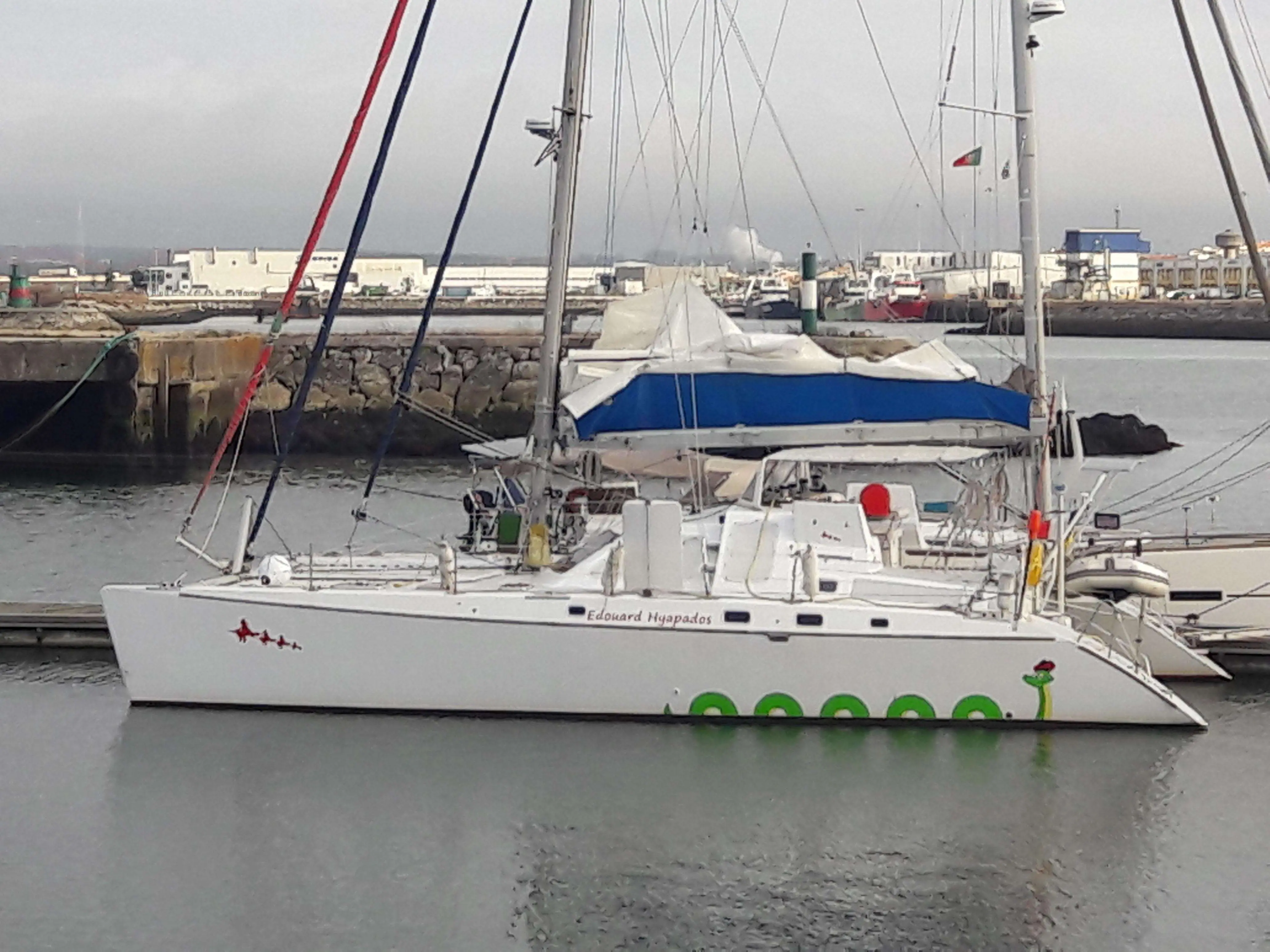 Custom Vplp 48 — Voilier blanc amarré dans un port, photographié de profil par temps couvert.