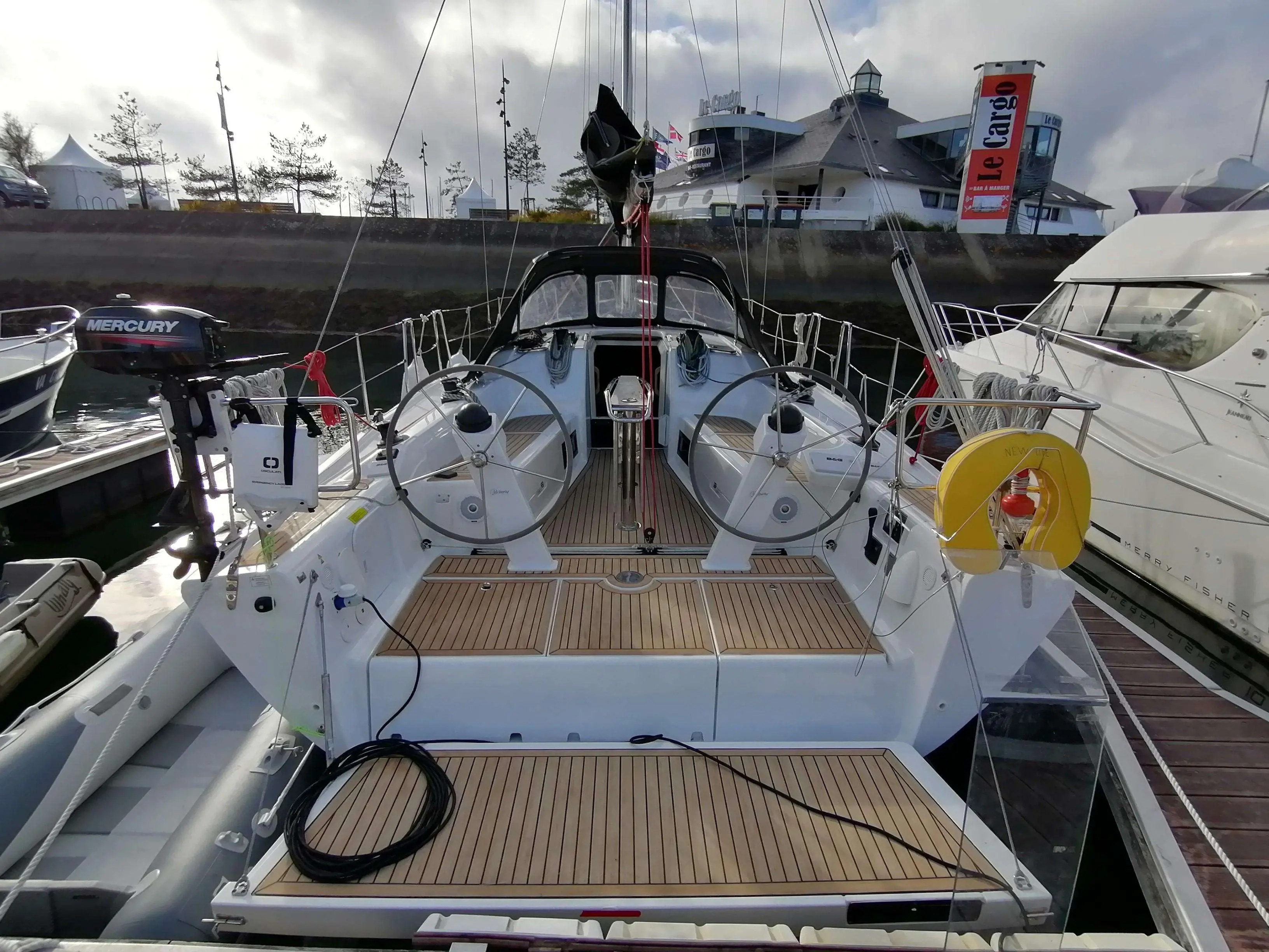 Dehler 38 — Vue arrière du cockpit d’un voilier amarré, avec double barre et table centrale.