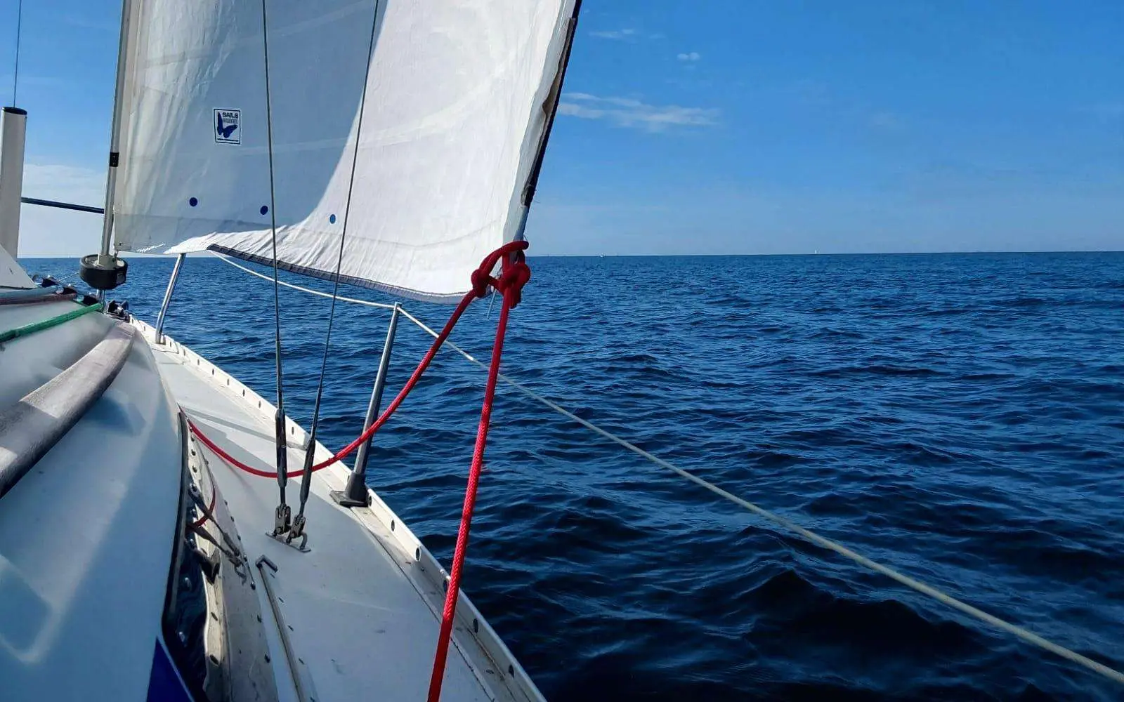 Beneteau First 235 — Vue depuis le pont avant d’un voilier naviguant en mer, voiles hissées.