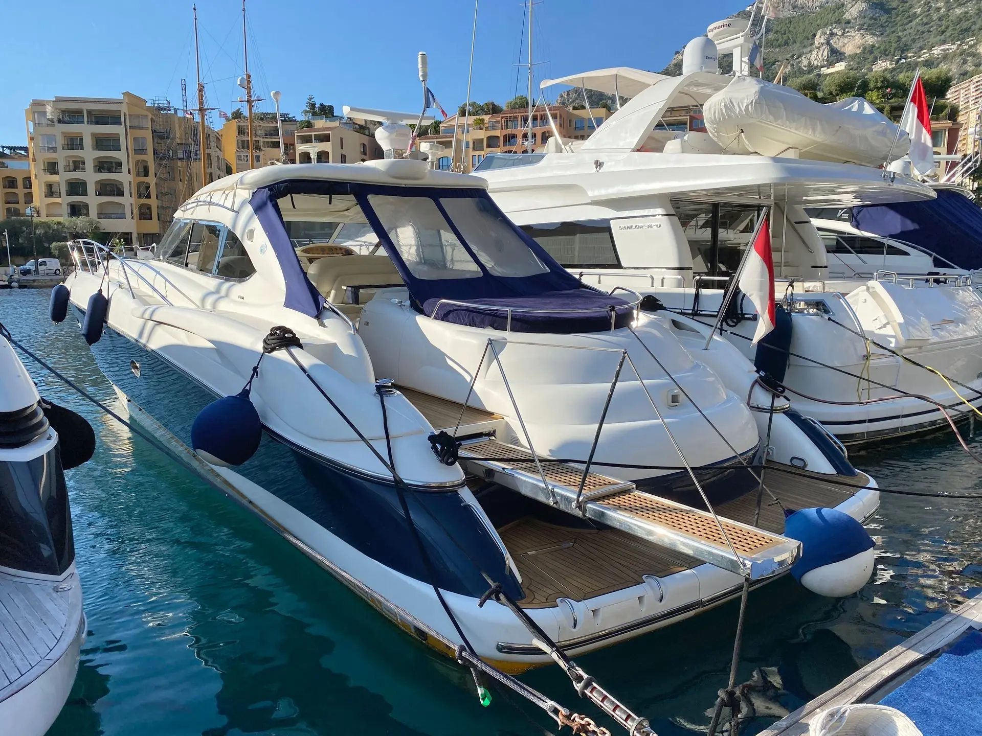 Sunseeker Predator 58 — Bateau à moteur blanc et bleu amarré dans un port, vu en trois-quarts arrière.