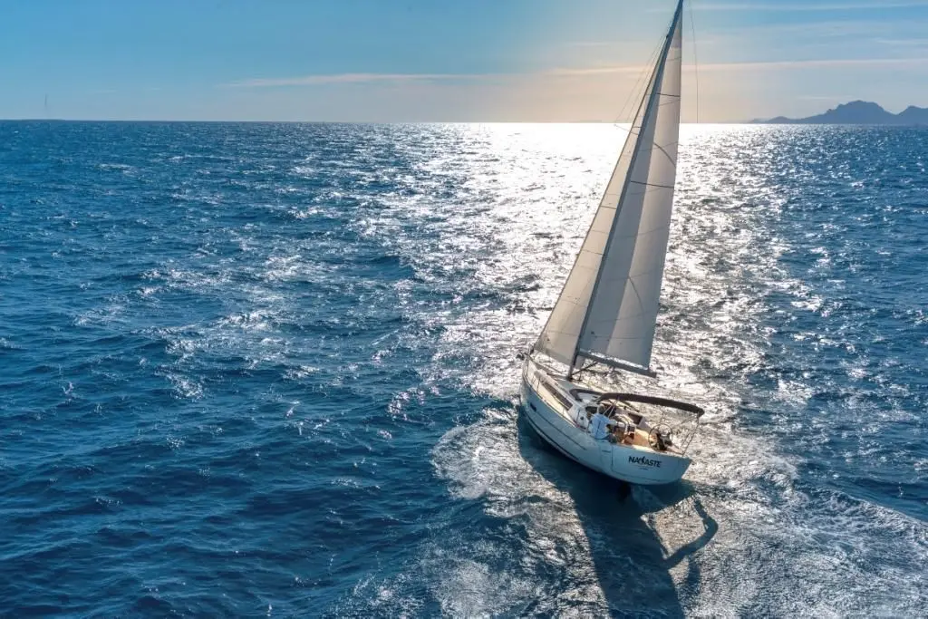 Dufour 360 — Voilier blanc naviguant au large, toutes voiles hissées, vu en plongée.
