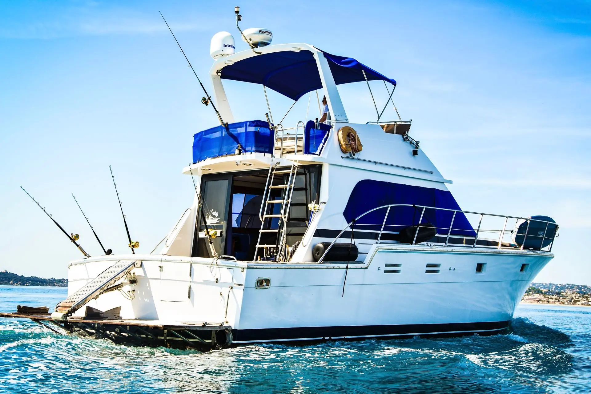 Hi Star 48 Fisherman — Bateau à moteur blanc et bleu naviguant, vu de trois quarts arrière.