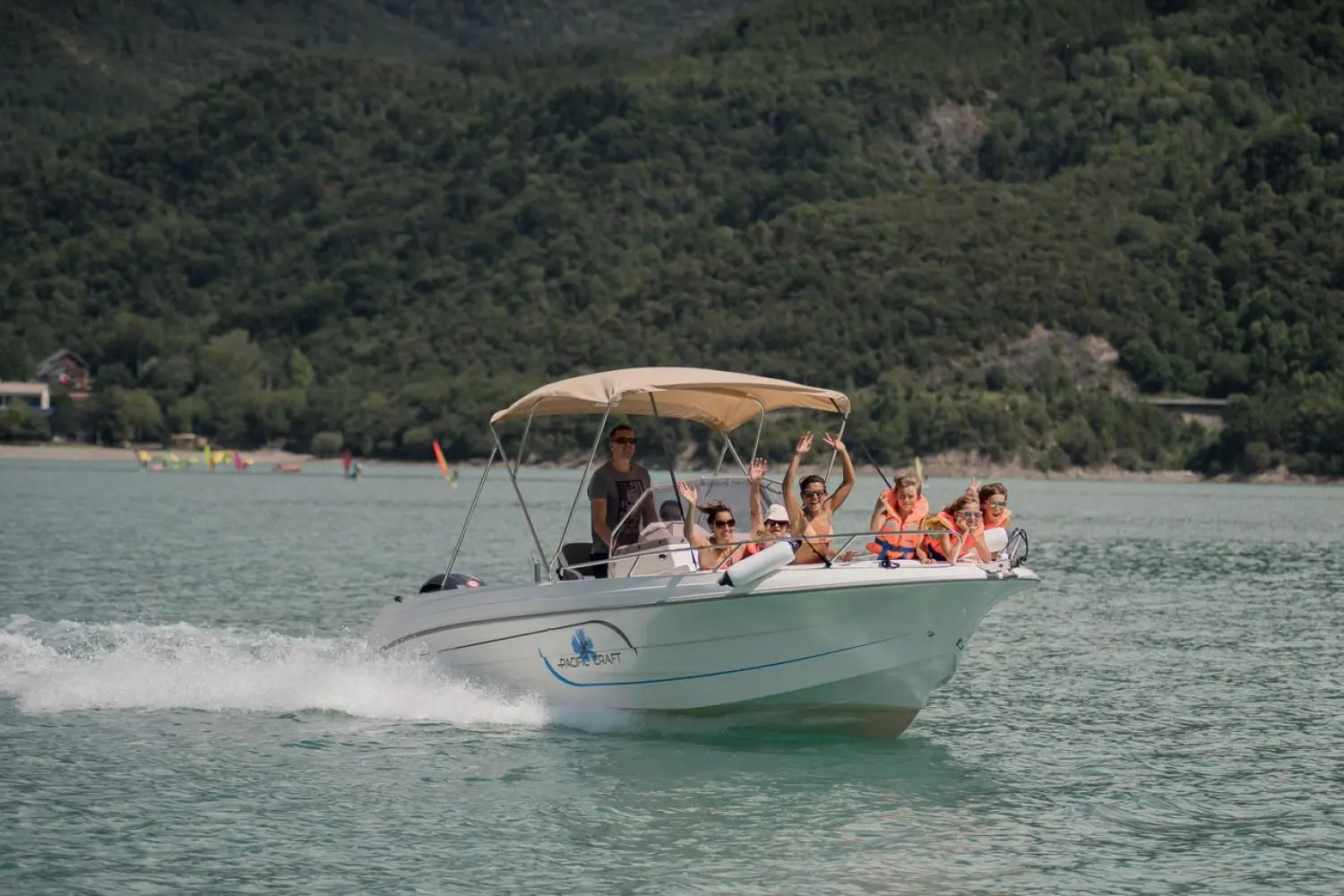 Pacific Craft 670 Plaisance 200cv — Bateau à moteur naviguant avec plusieurs passagers sur un lac.