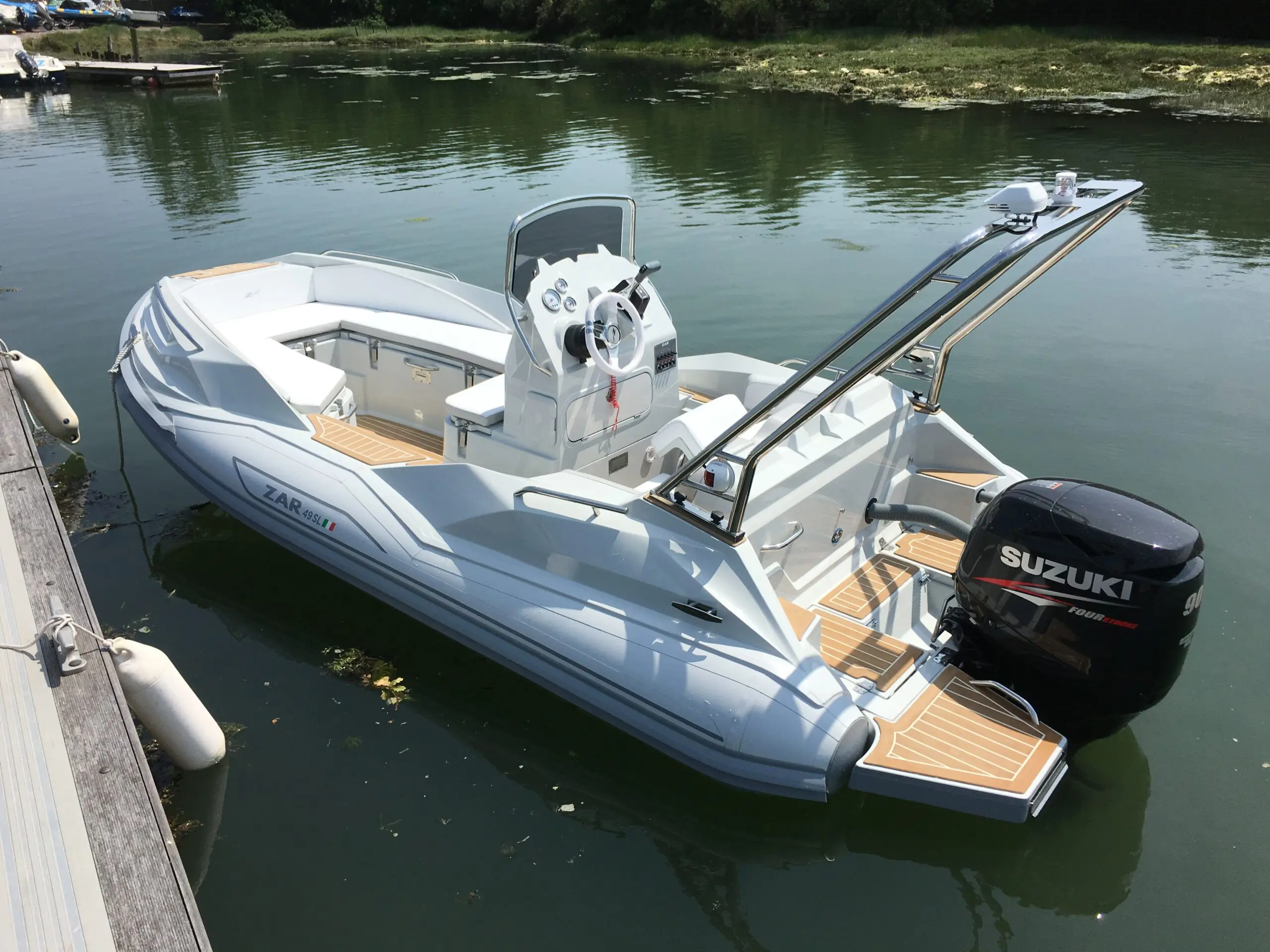 Zar Formenti Zar 49 SL — Bateau semi-rigide blanc amarré au ponton, vu de trois quarts arrière.