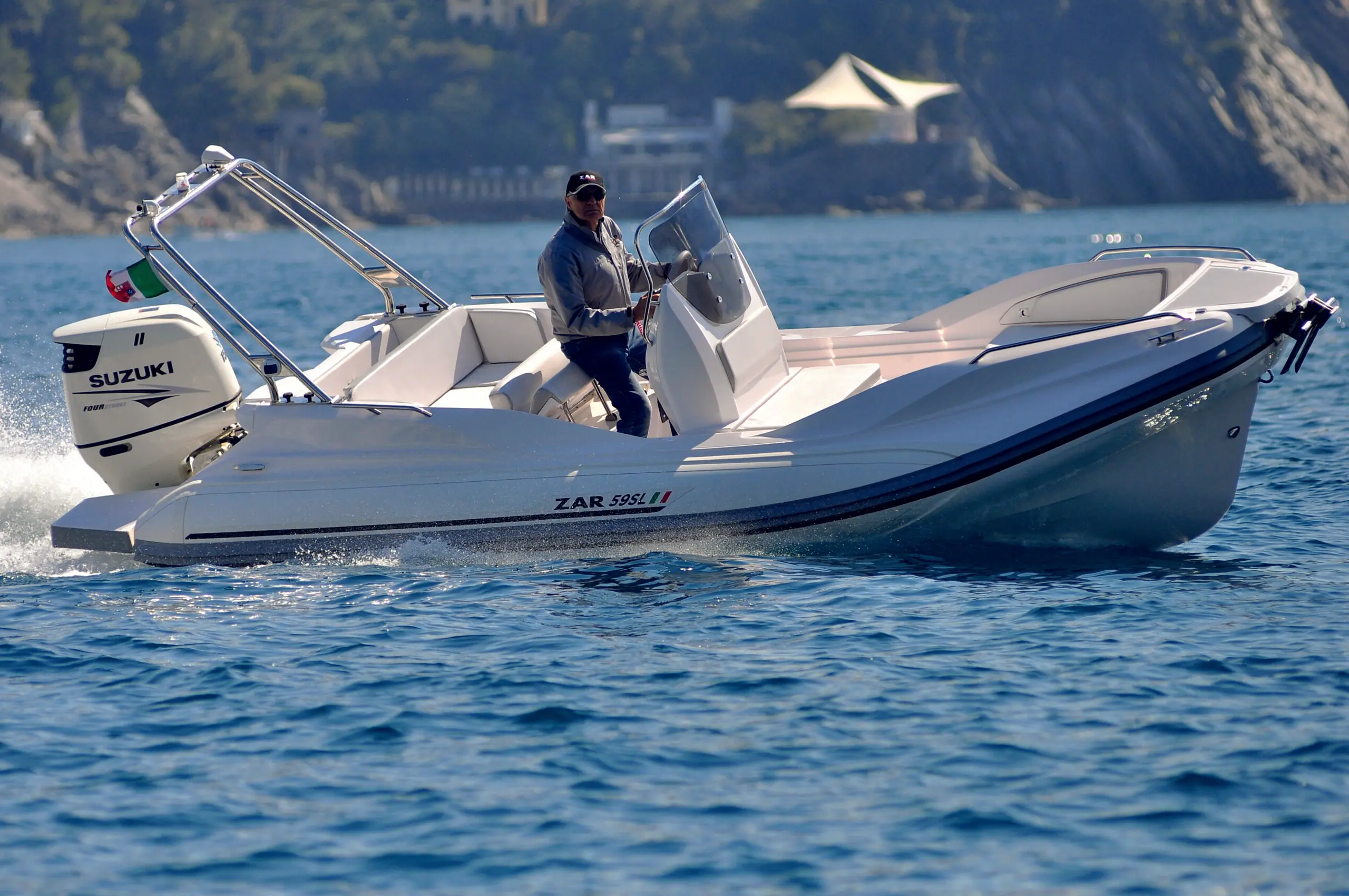 Zar Formenti Zar 59 Sl — Bateau semi-rigide blanc naviguant sur un lac, vu de profil avec un pilote à bord.