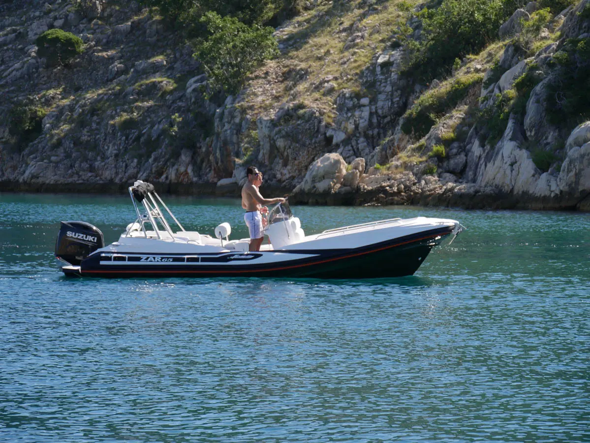 Zar Formenti Zar 65 Suite — Bateau pneumatique à moteur naviguant devant une côte rocheuse.