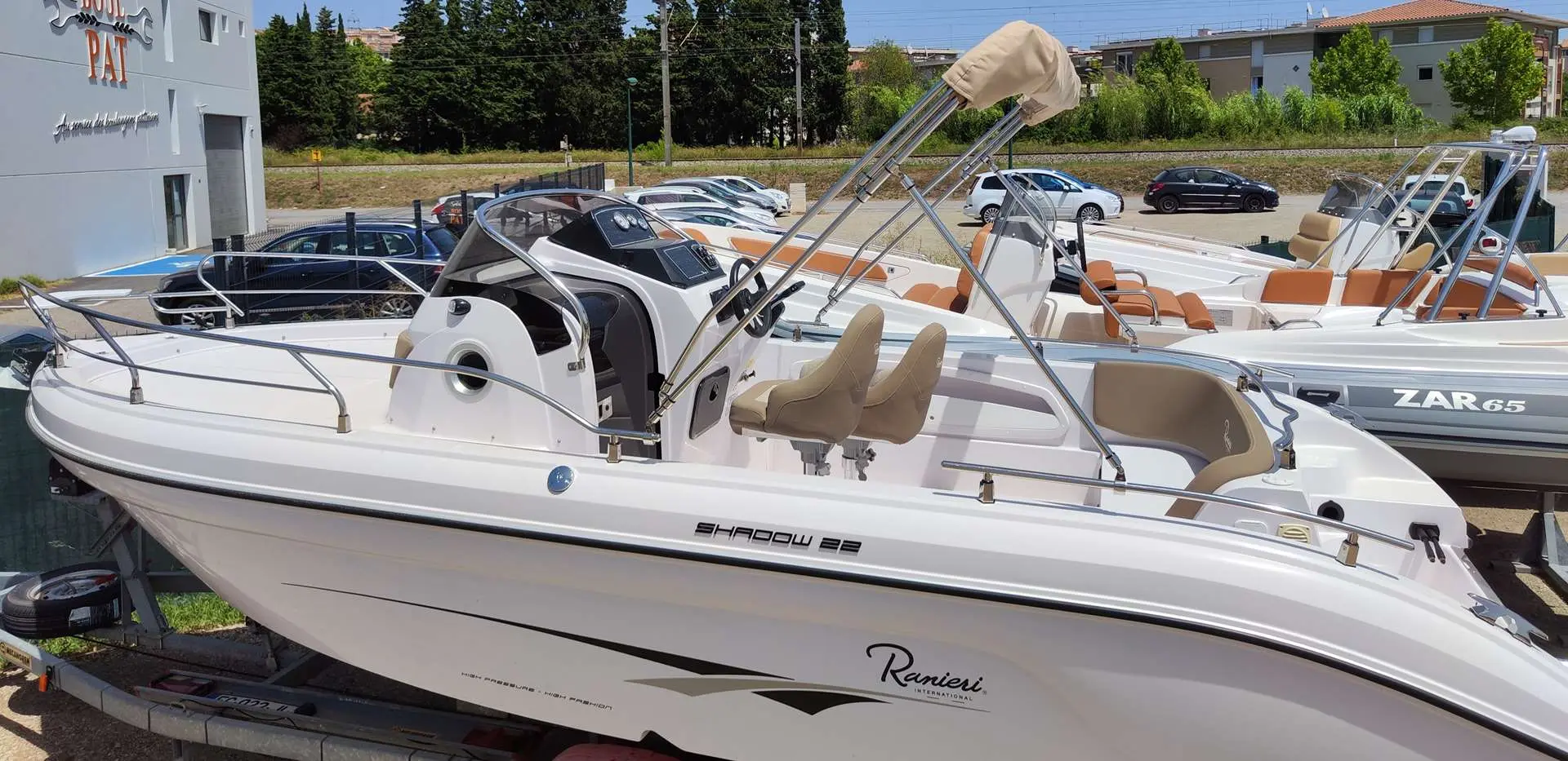 Ranieri Shadow 22 — Bateau à moteur blanc présenté sur remorque, vu de trois quarts dans un parc nautique.