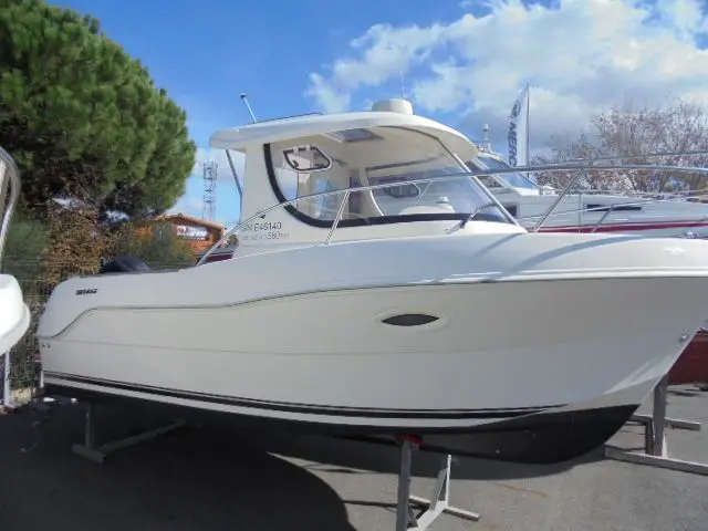 Quicksilver Pilothouse 580 — Bateau à moteur blanc sur remorque, photographié de trois quarts par l’avant.