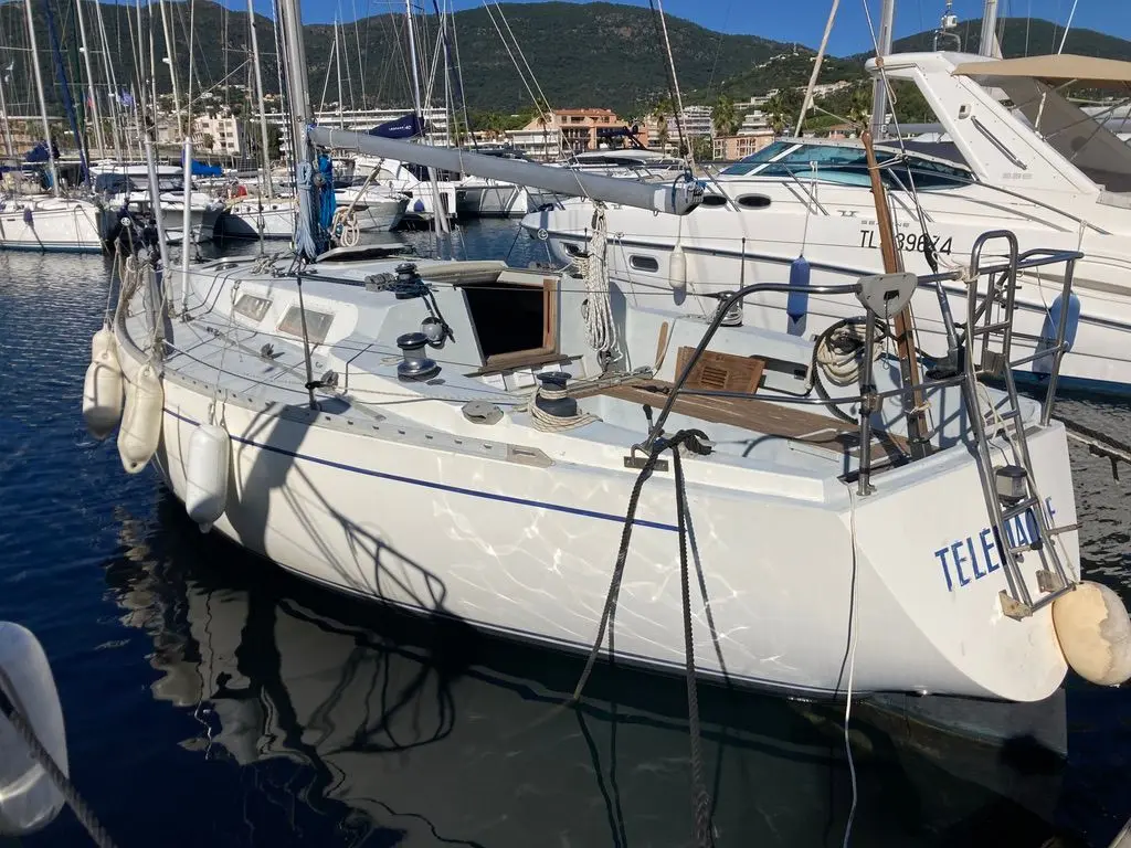 Contessa 35 — Voilier blanc amarré dans un port, vu de trois quarts arrière.