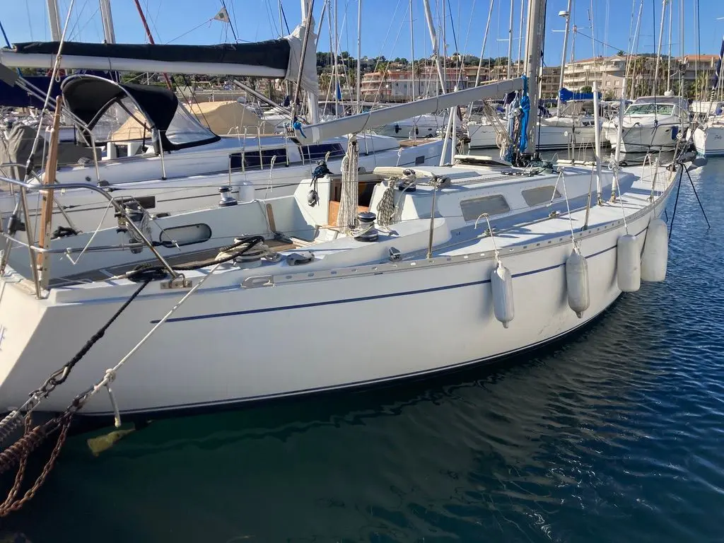 Contessa 35 — Voilier blanc amarré dans une marina, vu de profil partiel.