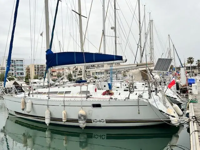 Kirie Feeling 1040 — Voilier blanc amarré dans une marina, vu de trois quarts tribord.