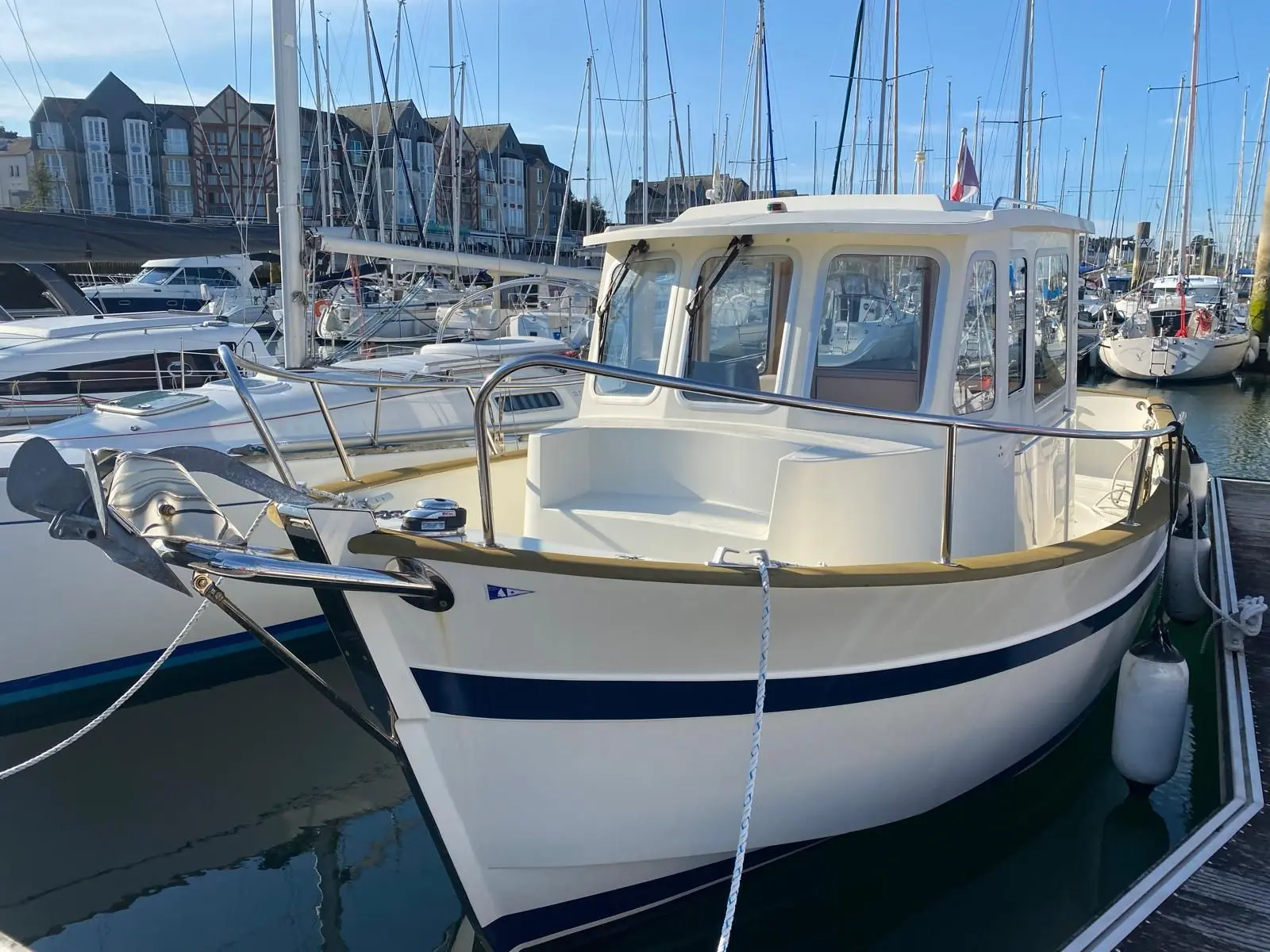 Rhea 730 Fishing — Bateau à cabine blanche amarré dans un port de plaisance.