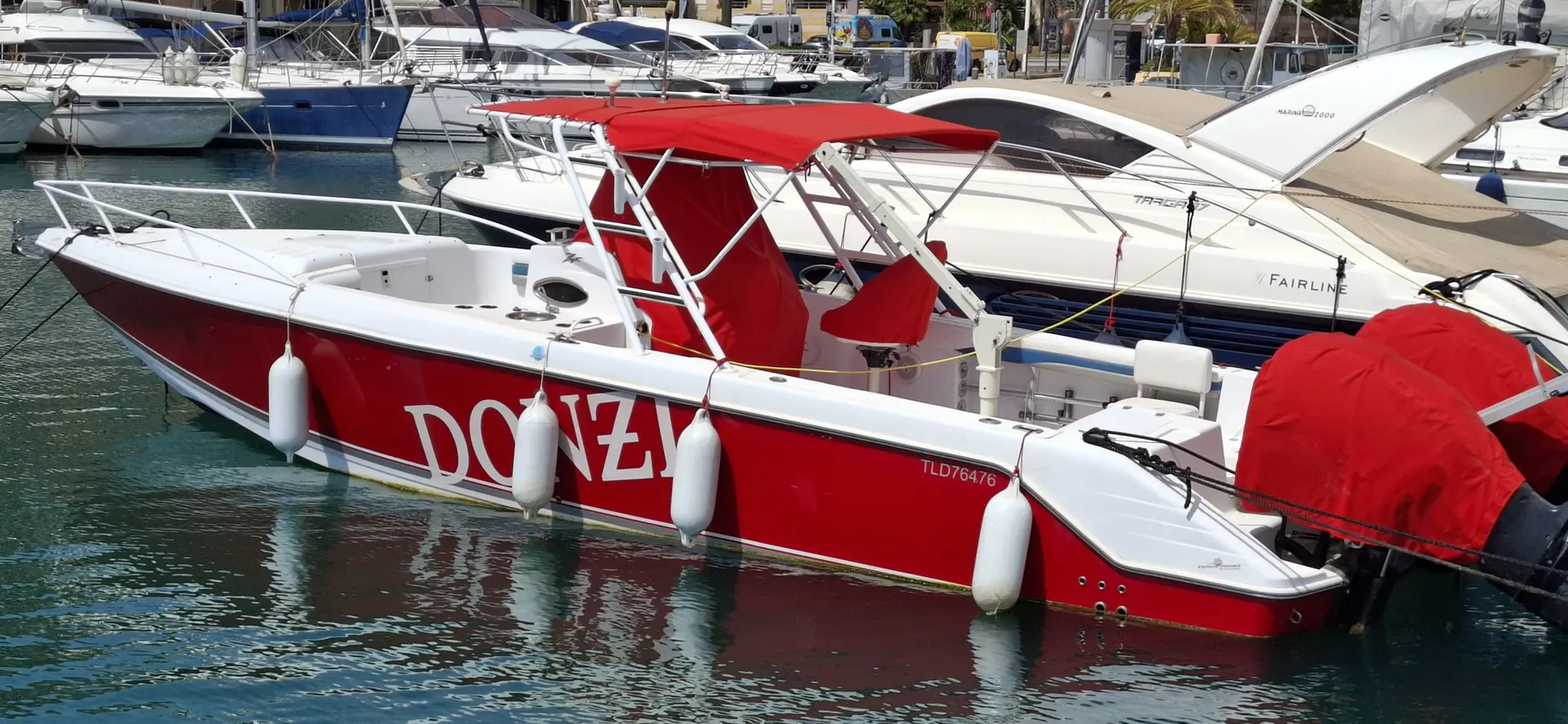 Donzi 35 ZFX — Bateau à moteur rouge et blanc amarré dans un port, vu de trois quarts.