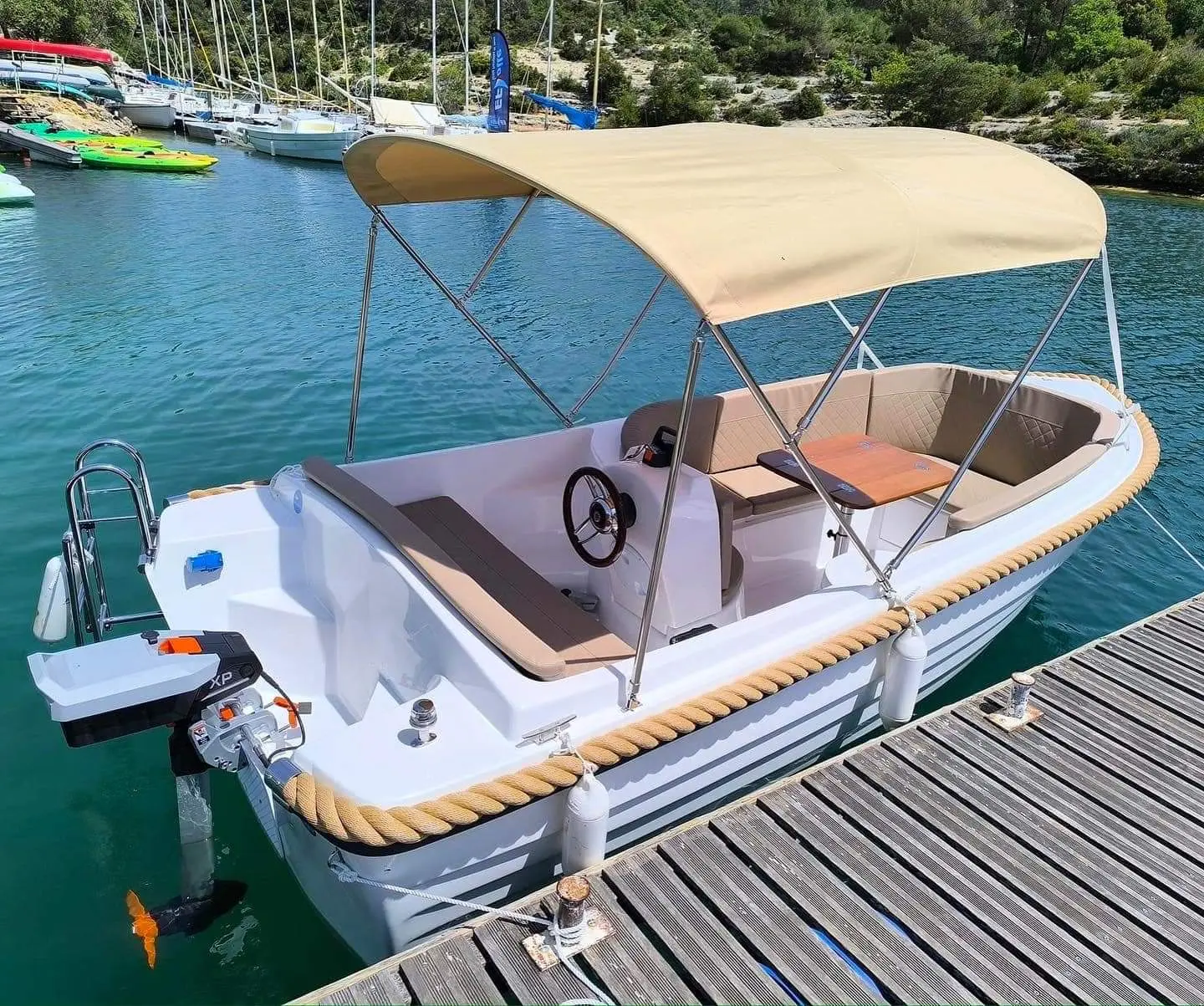 Kruger Delta — Bateau à moteur amarré, équipé d’un taud beige et d’un cockpit avec table.
