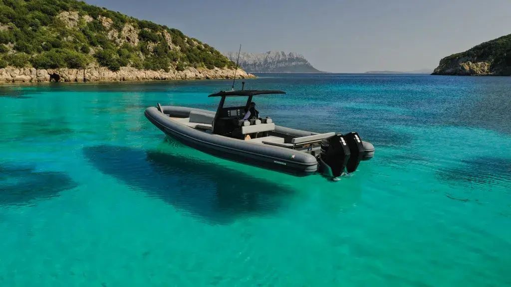 Novamarine RH 1000 — Bateau semi-rigide noir équipé de deux moteurs hors-bord dans une crique turquoise.