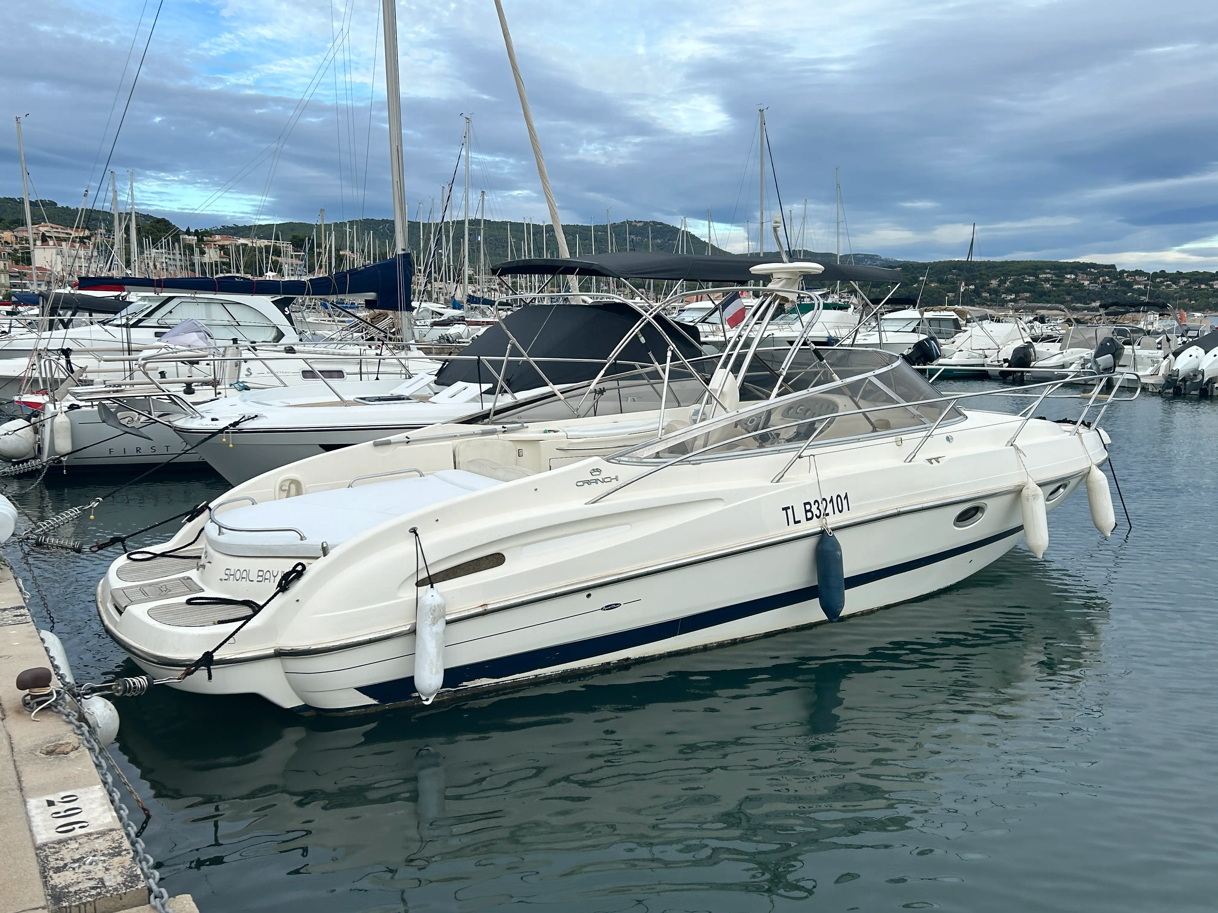 Cranchi 28 — Bateau à moteur blanc amarré dans un port, vu de trois quarts tribord.