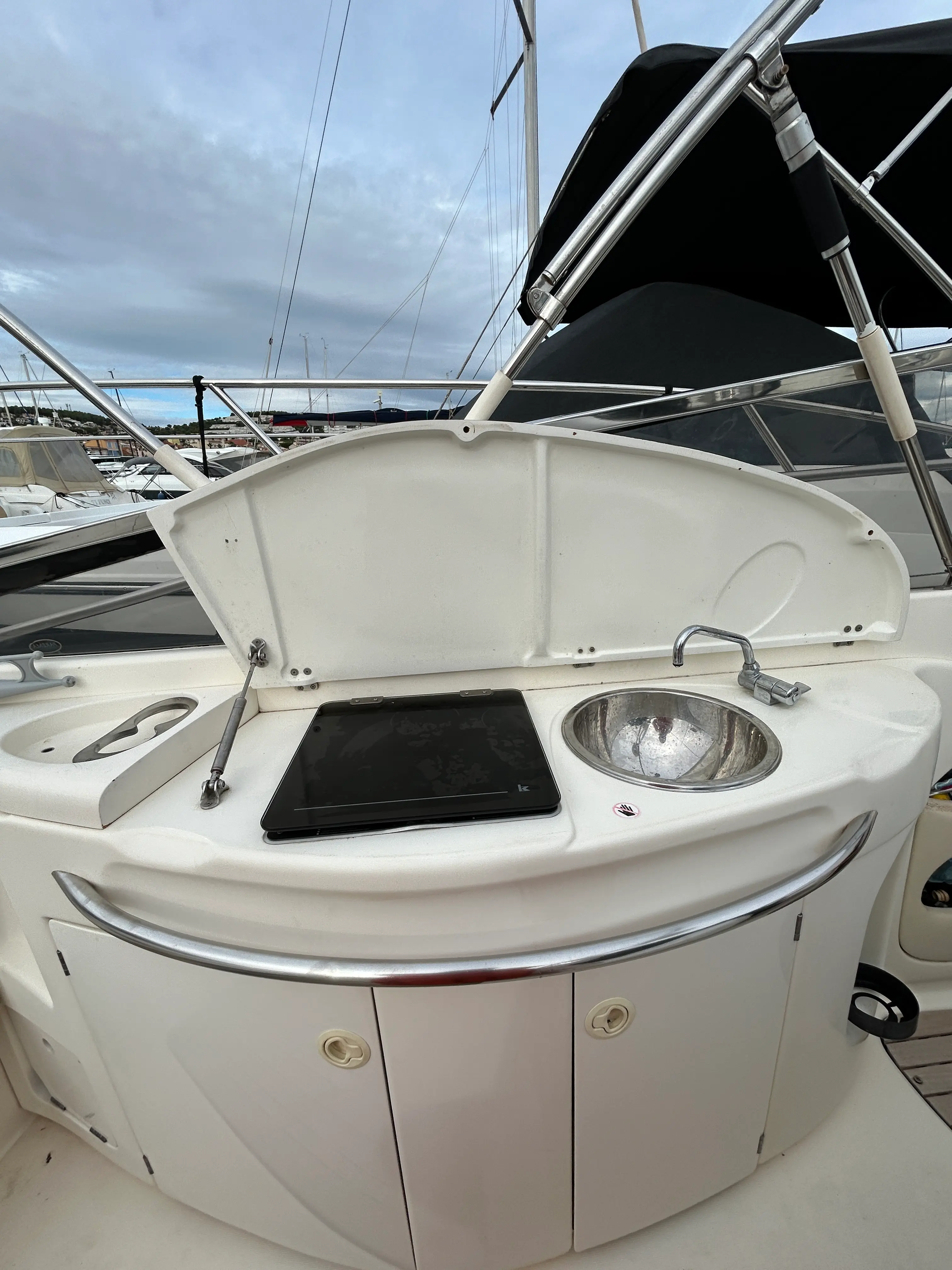 Cranchi 28 — Vue rapprochée d’un meuble de cockpit avec évier, robinet et plaque noire.