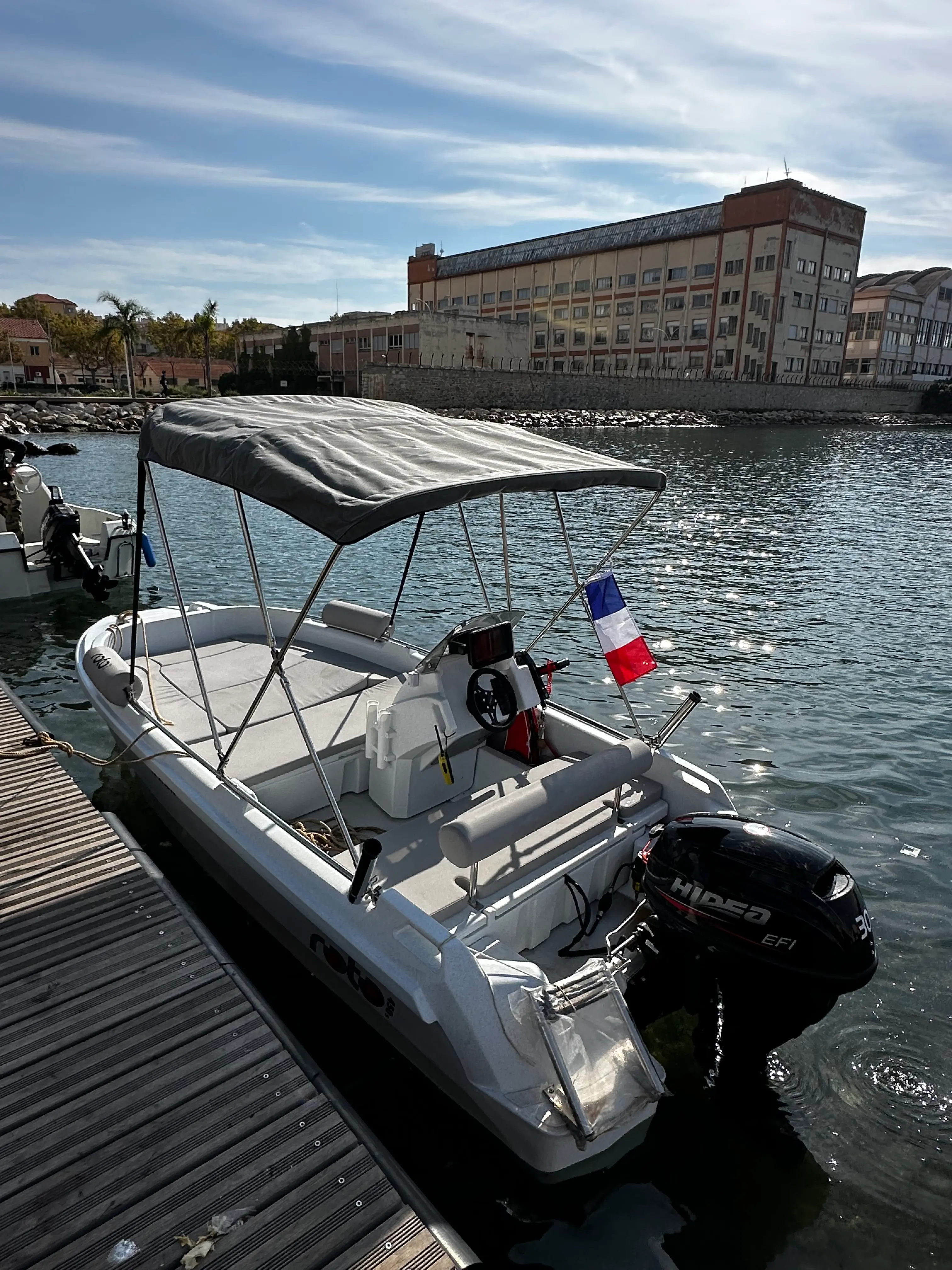 Roto 450 S — Bateau semi-rigide amarré, équipé d’un taud et d’un moteur hors-bord.
