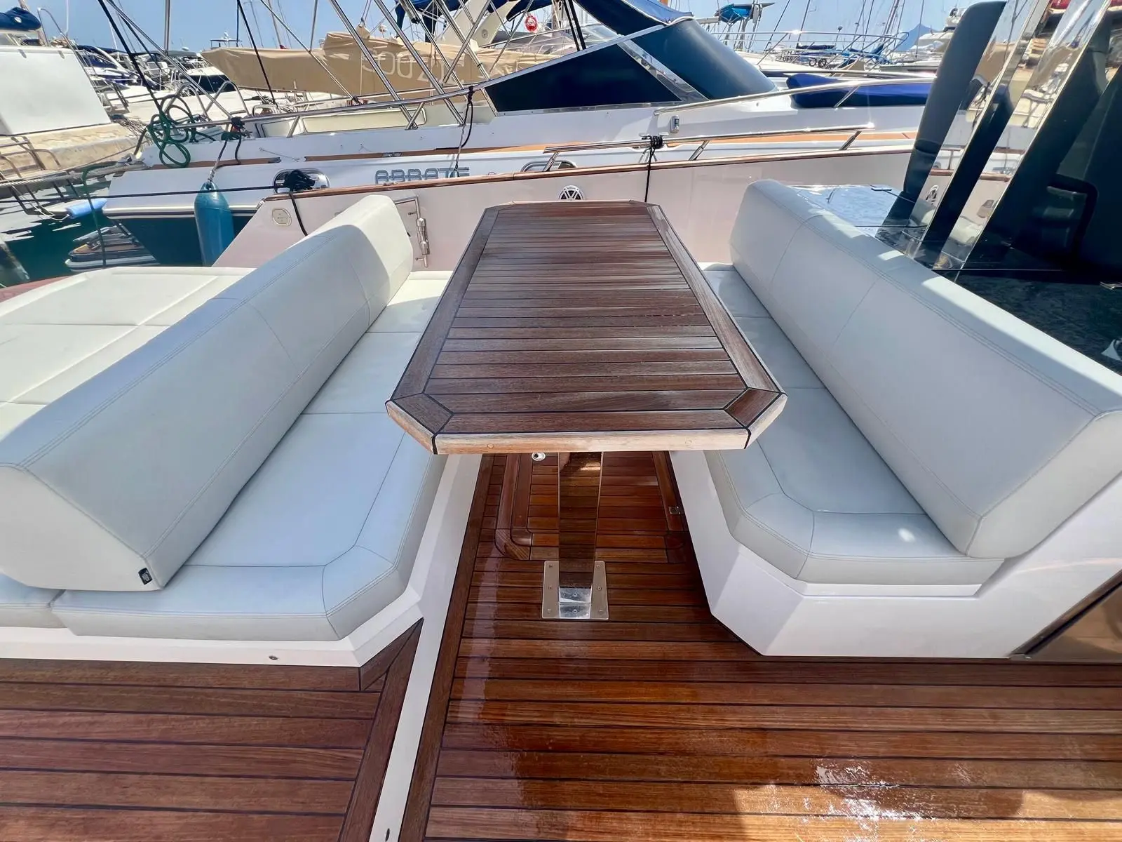 Focus Yachts Forza 37 — Cockpit arrière avec table en teck et banquettes blanches.