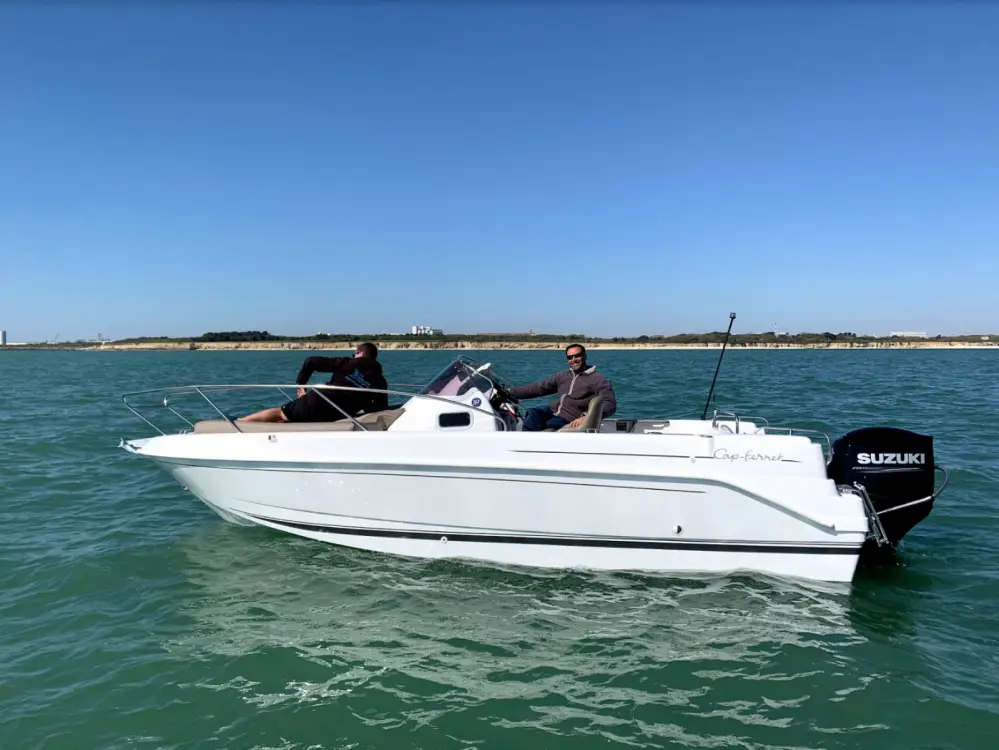 B2 Marine 652 — Bateau à moteur blanc photographié de profil sur l’eau, avec deux personnes à bord.