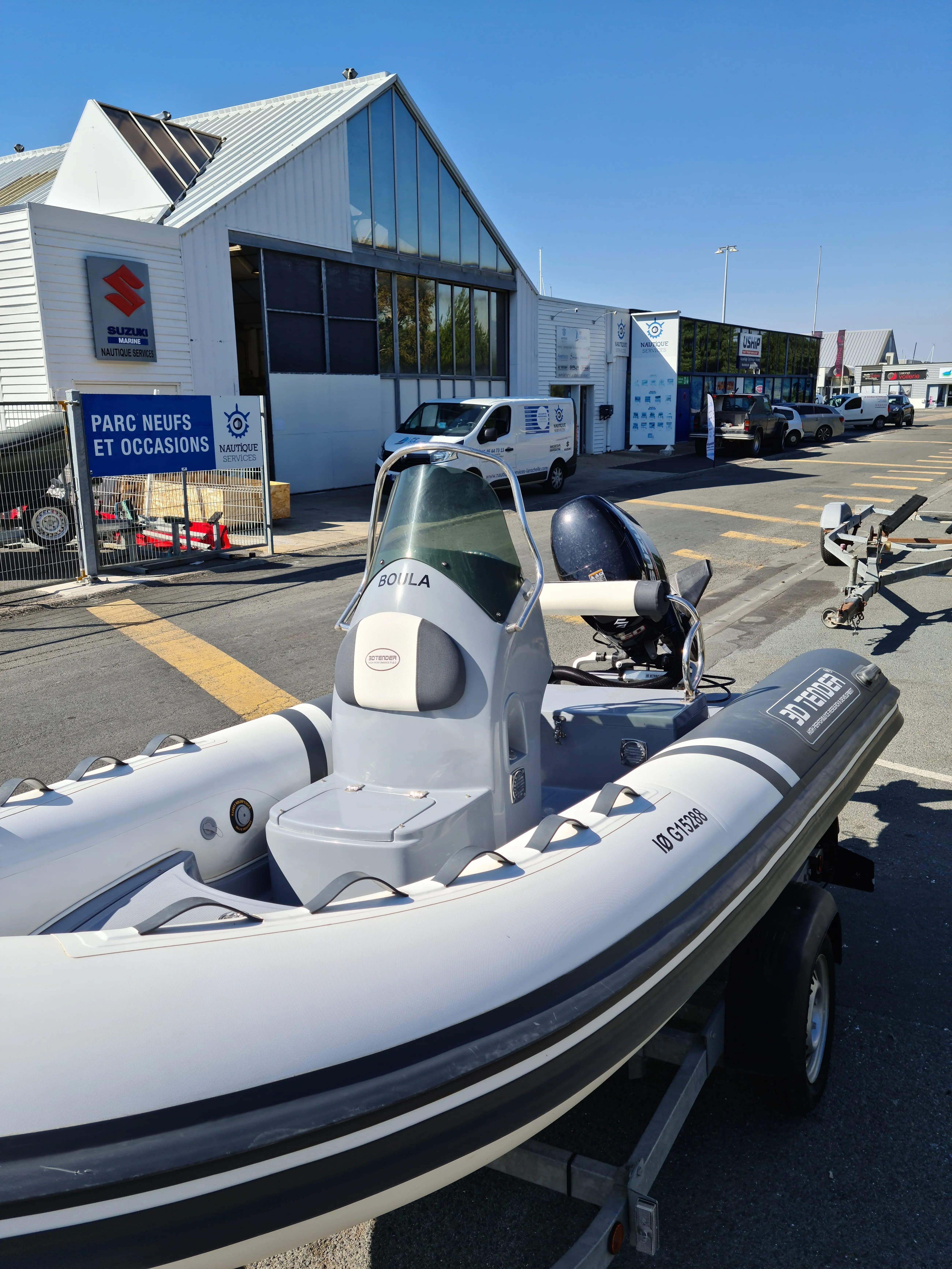 3D Tender Lux 440 — Vue rapprochée d’un bateau semi-rigide sur remorque devant un concessionnaire.