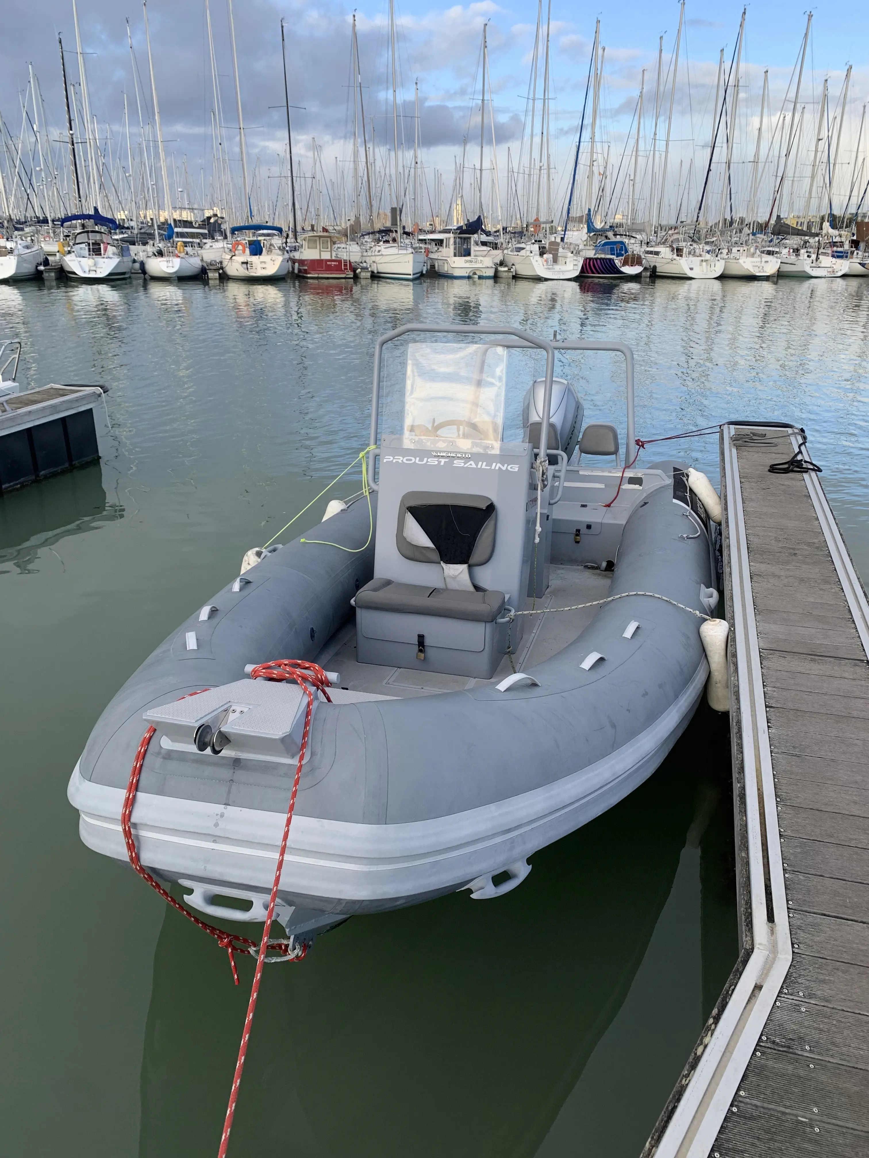 Highfield OM 590 — Bateau semi-rigide amarré dans un port de plaisance, vu de trois quarts.