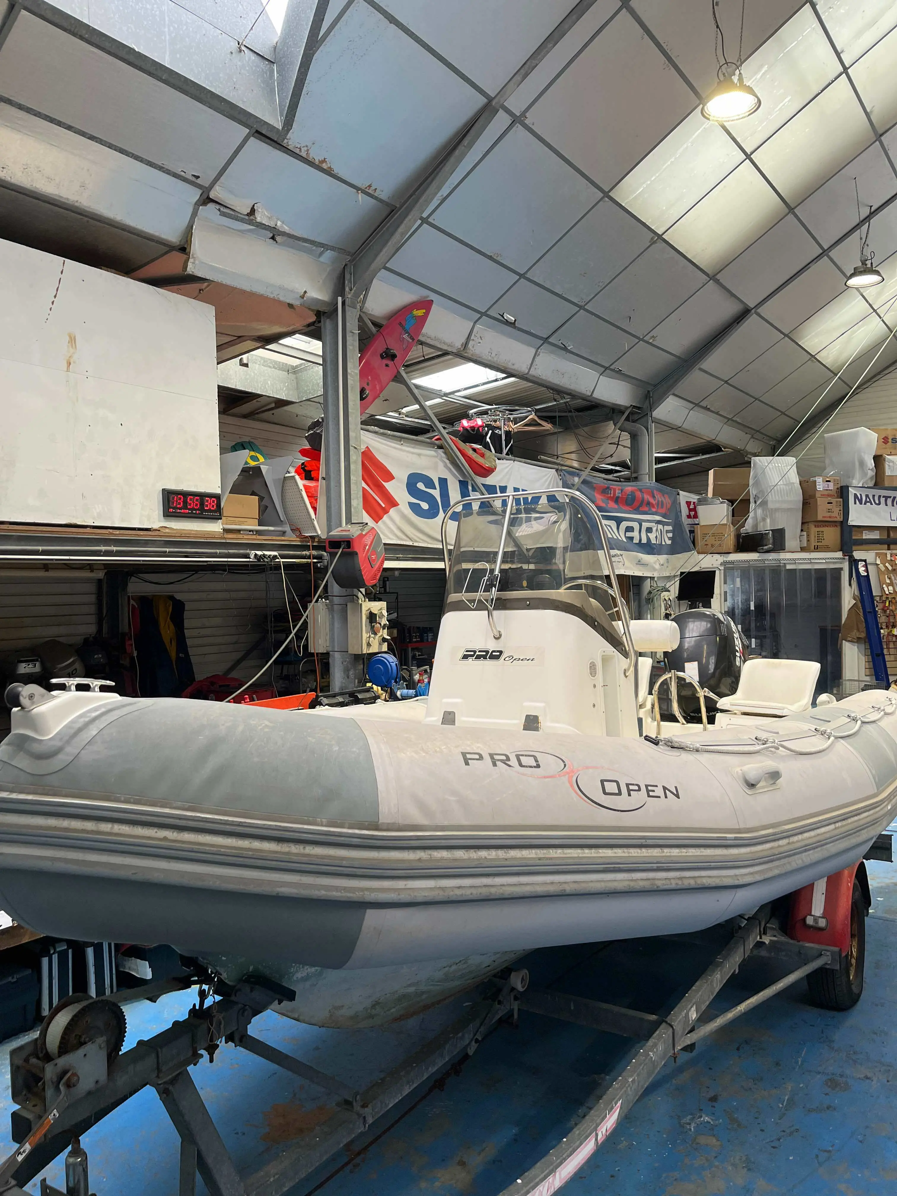 Zodiac Pro Open — Bateau pneumatique à console et moteur hors-bord présenté sur une remorque en atelier.