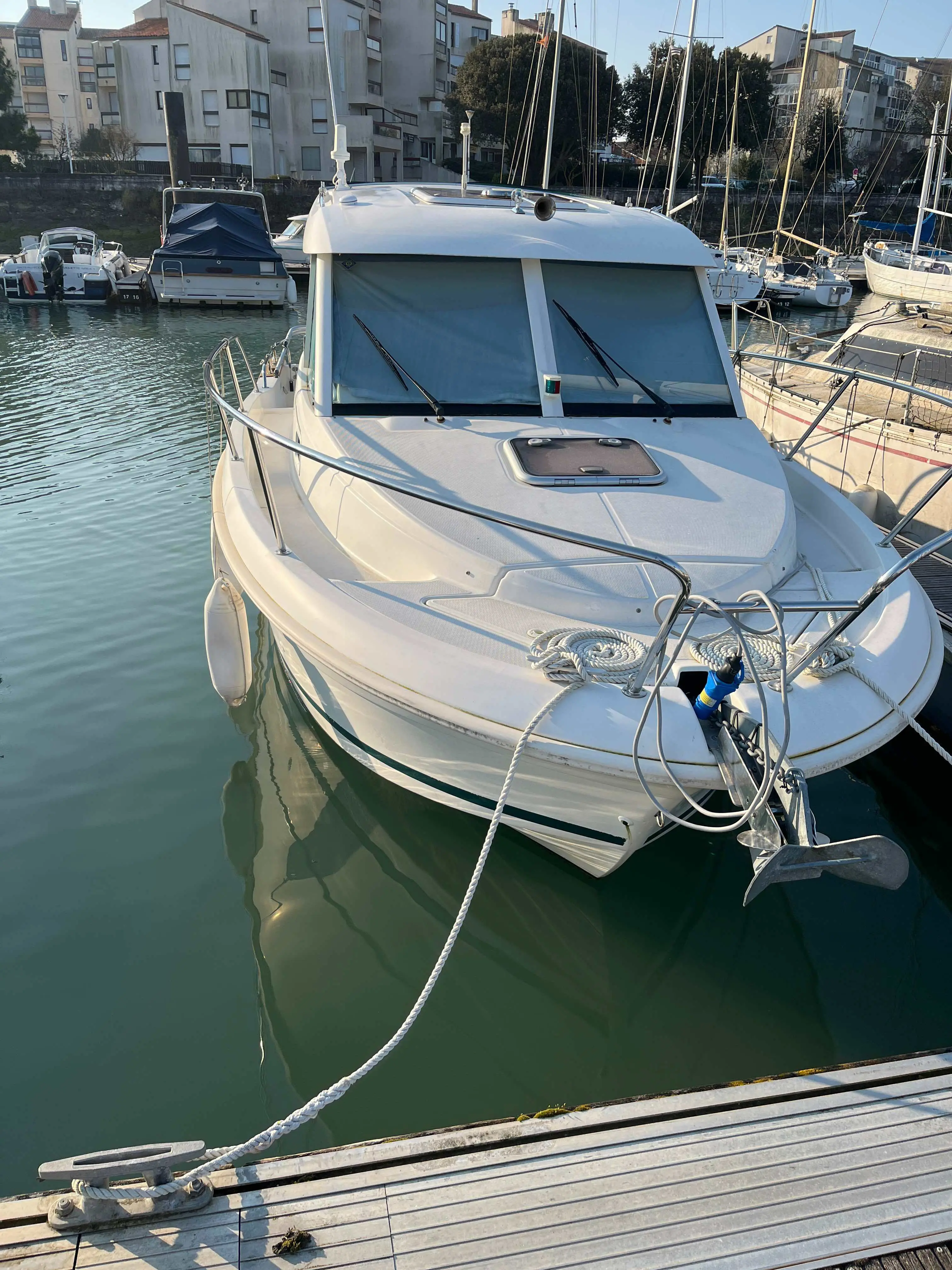 Jeanneau Merry Fisher 700 — Vue avant d’un bateau à moteur amarré dans une marina.