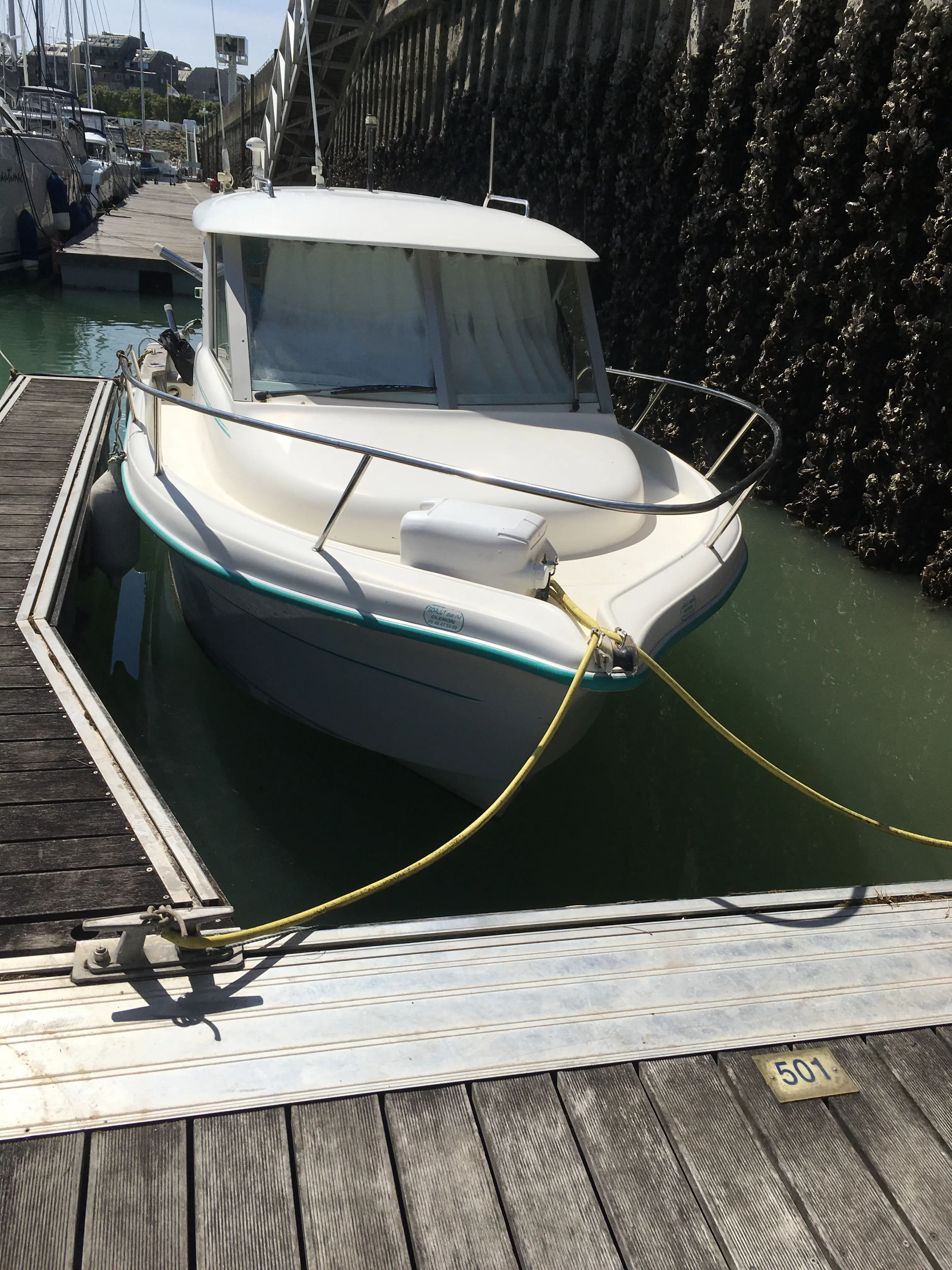 Ocqueteau 615 — Bateau à moteur amarré dans un port, vu de face depuis le ponton.